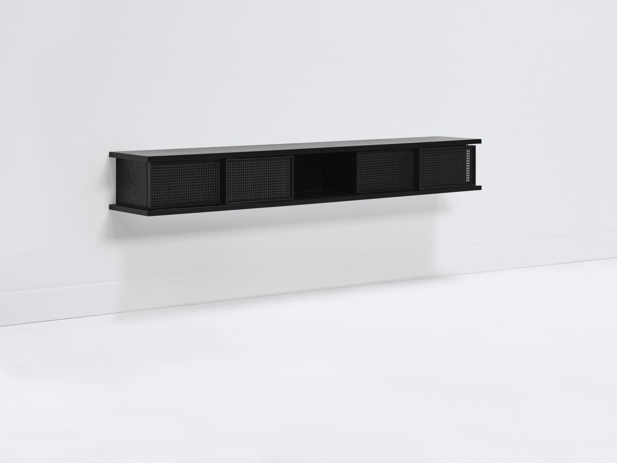 Front angle view of long black floating shelf with black cane doors