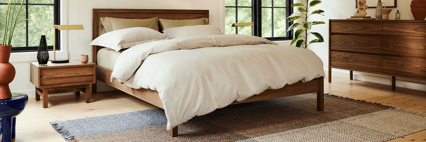 Walnut platform bedframe in modern bedroom with attached nightstands