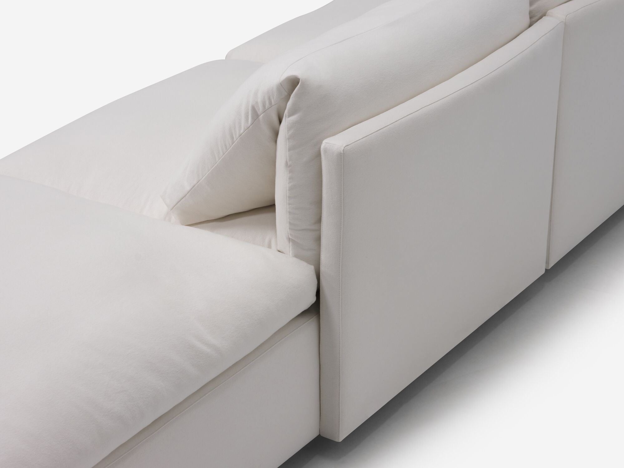 White sectional sofa with narrow arms and right hand chaise back detail view