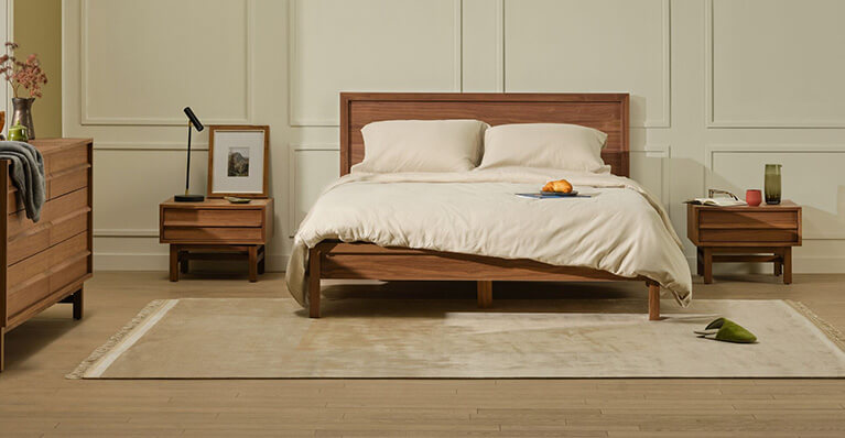 A queen walnut bed and matching storage is displayed in a modern bedroom. Link to room bundles