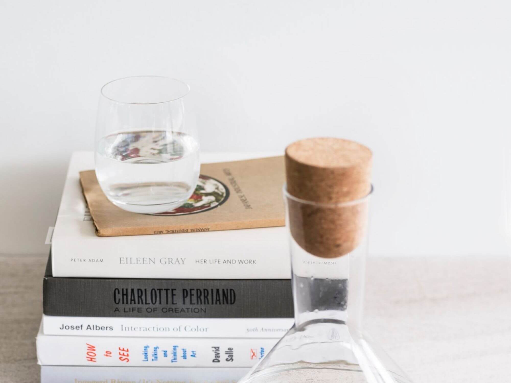 Modern tumbler glass on top of book stack with wine decanter