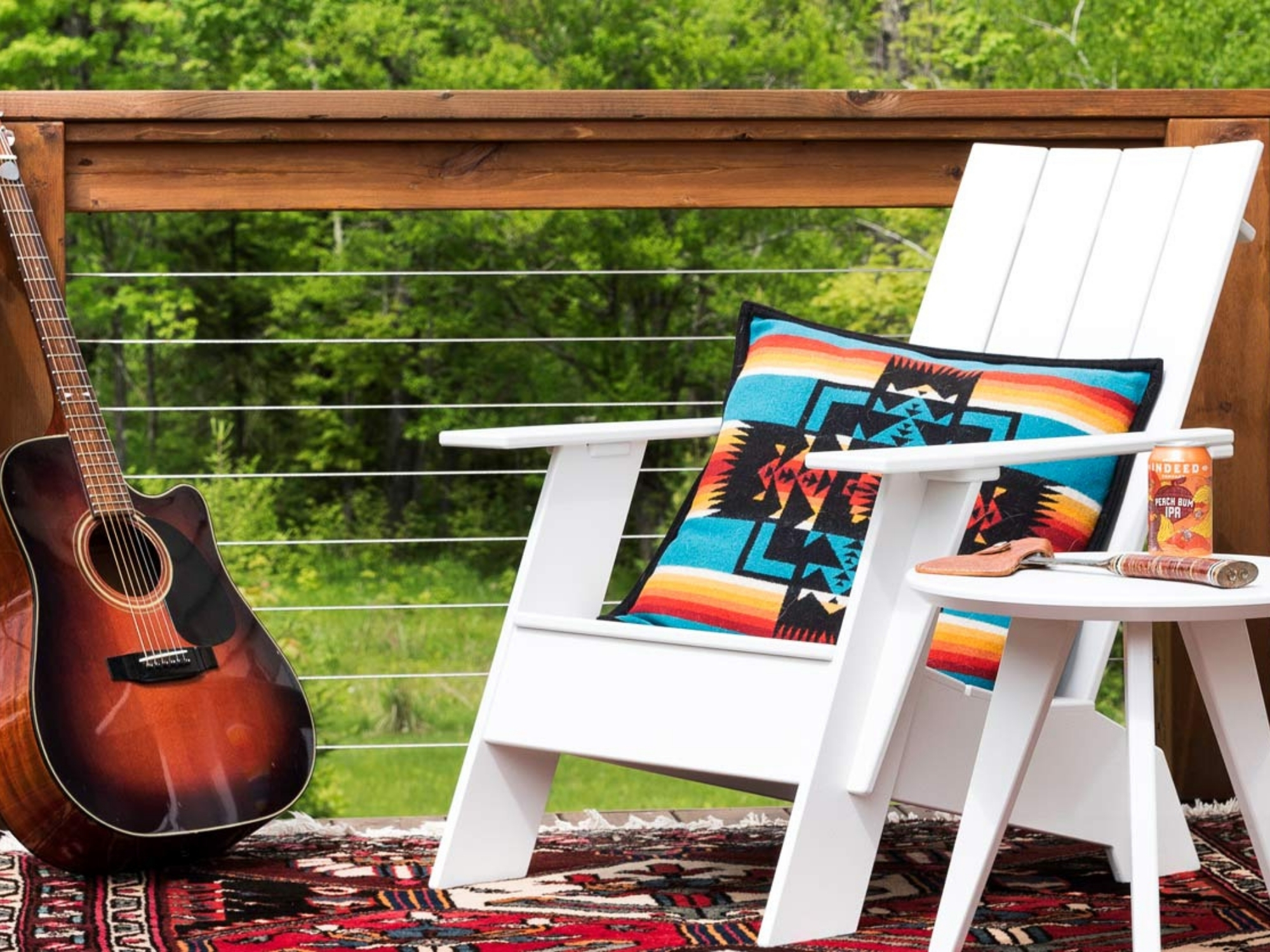 White outdoor chair and side table on a deck with a guitar