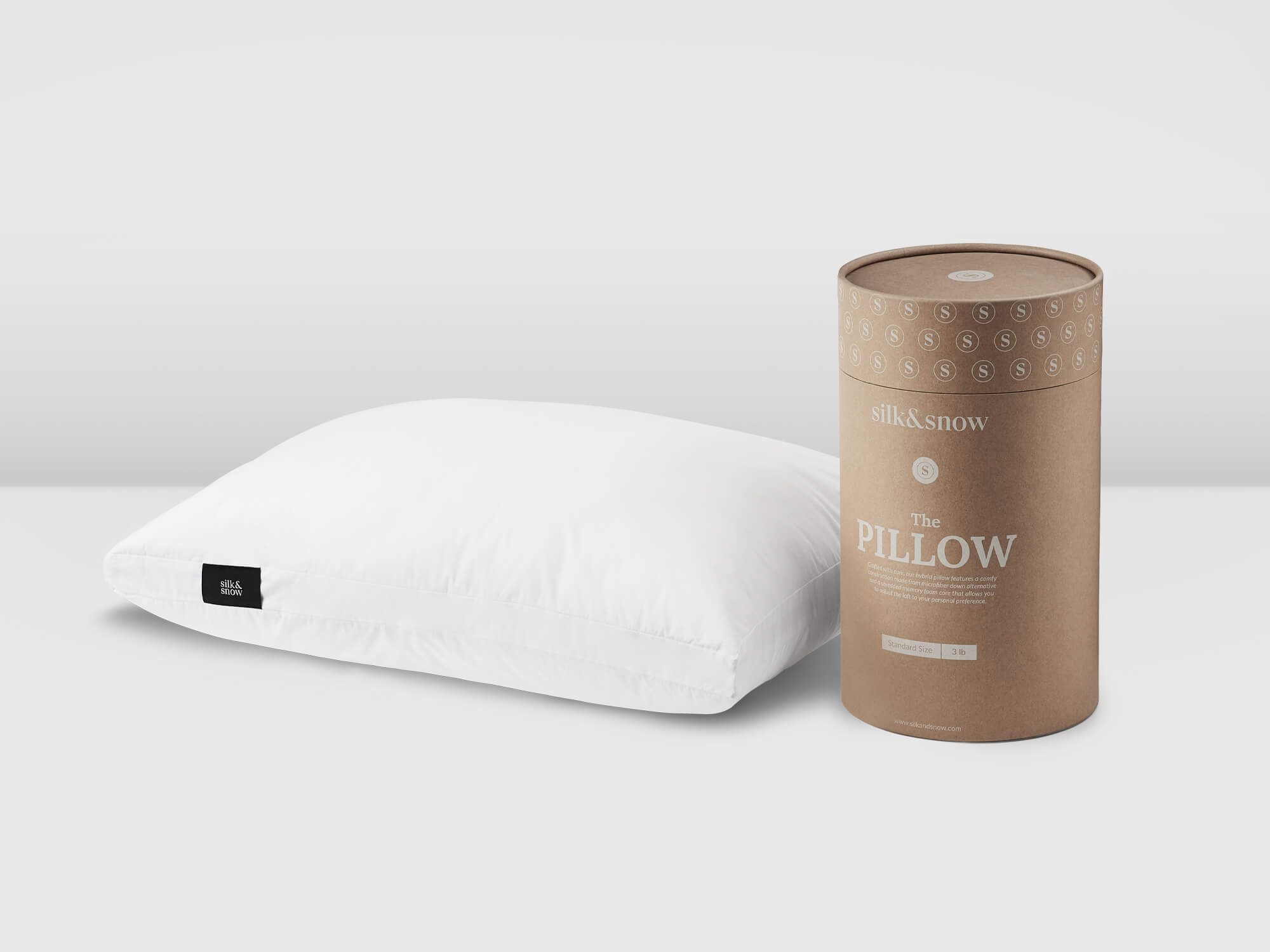 White pillow with black tag beside brown canister