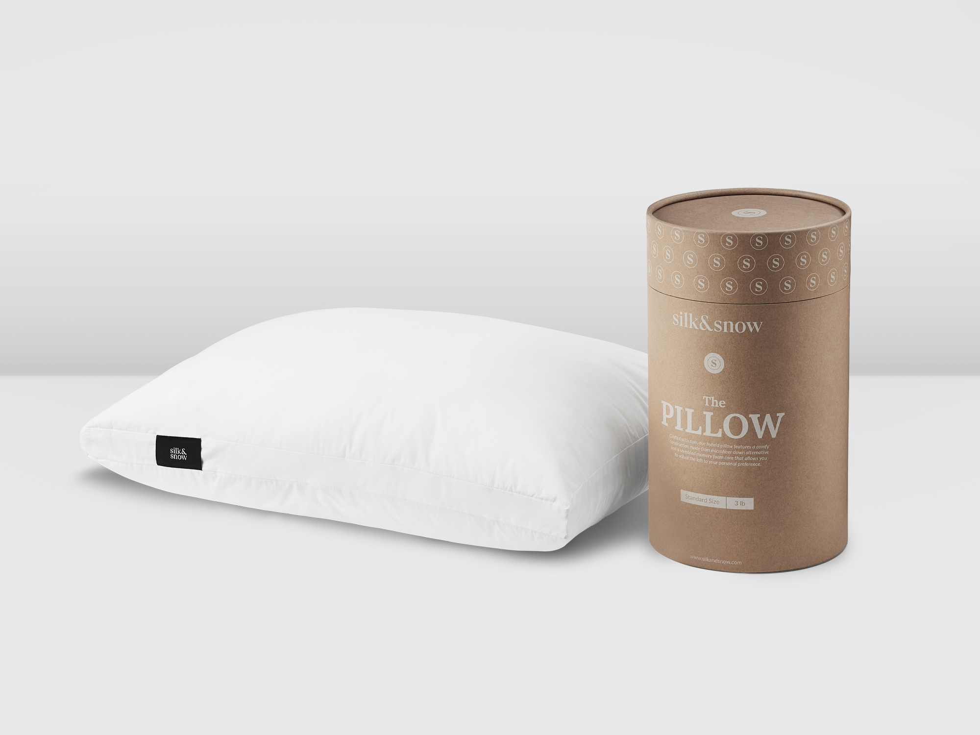 White pillow with black tag beside brown canister