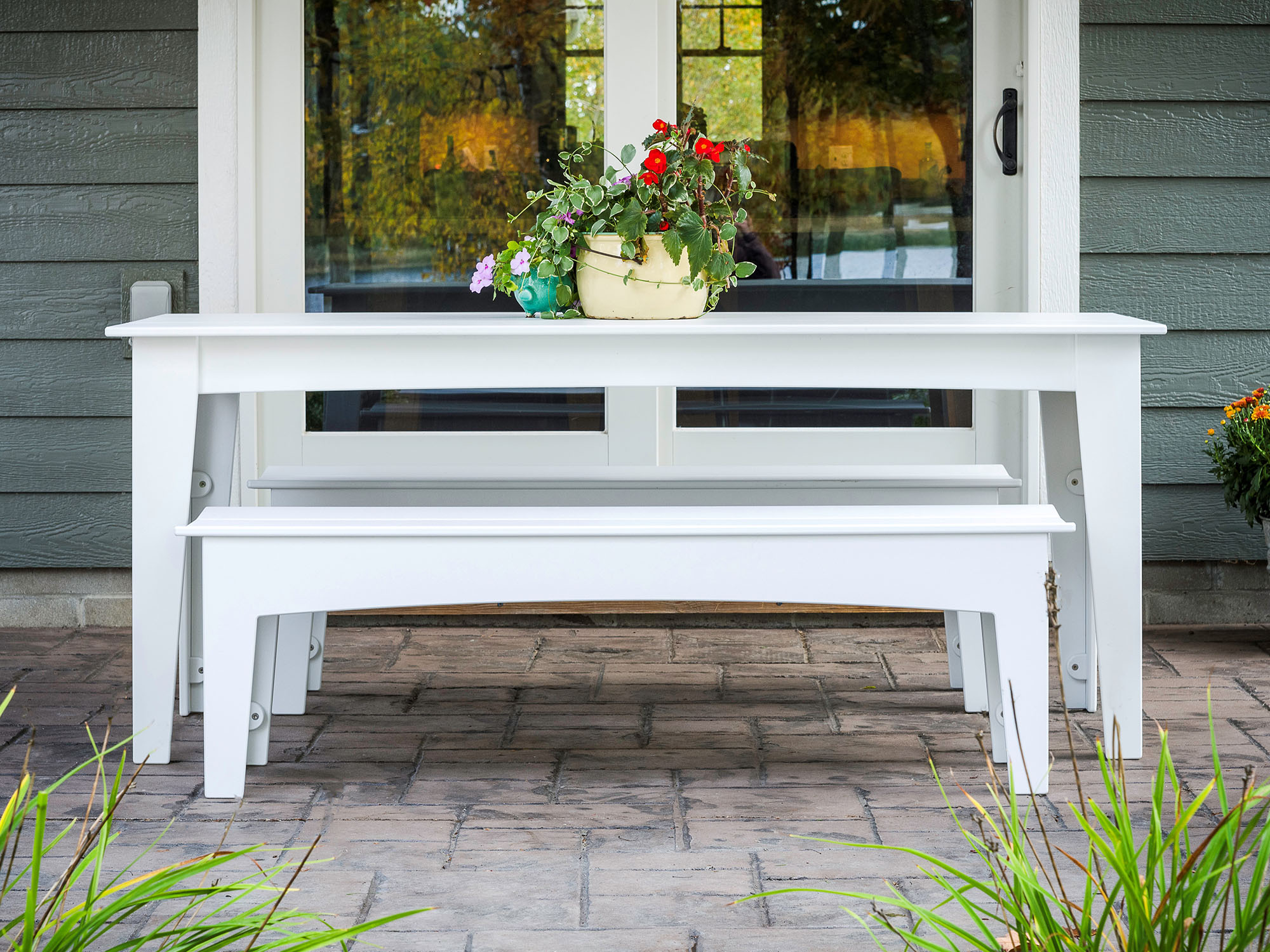 White outdoor bench and outdoor dining table on patio