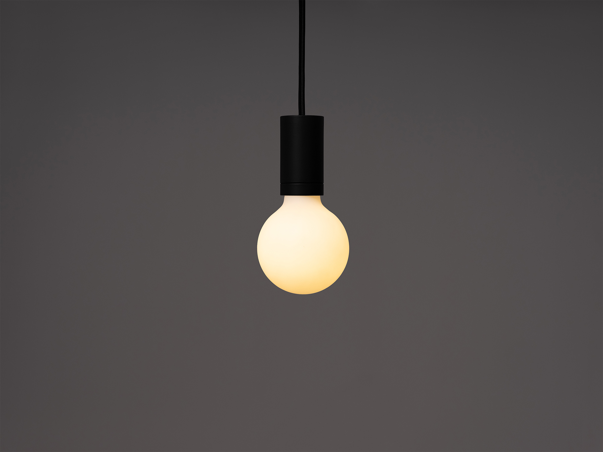 Small round matte white LED light bulb in a pendant