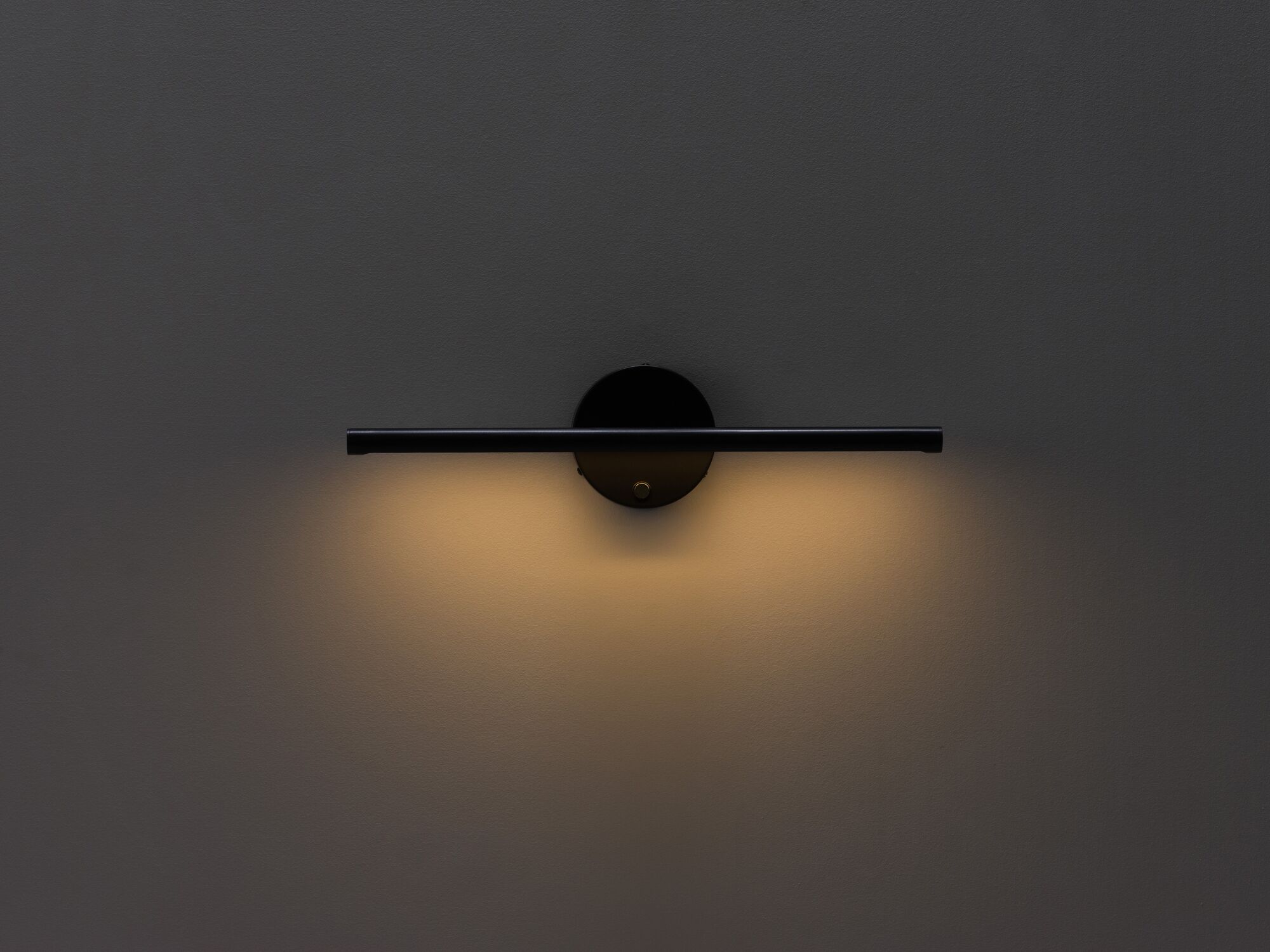 Black slim wall lamp with light on low front view