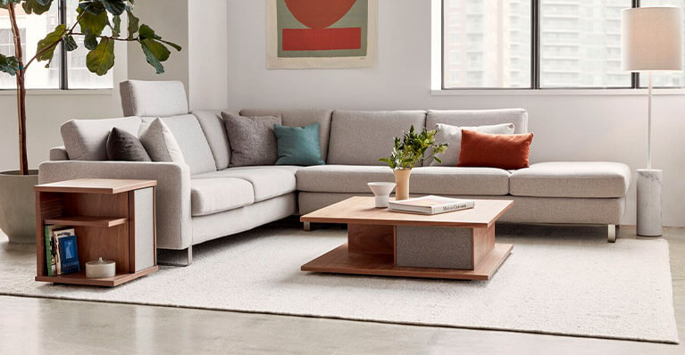 large grey oskar sectional fabric sofa is displayed in a living room. Link to seating category