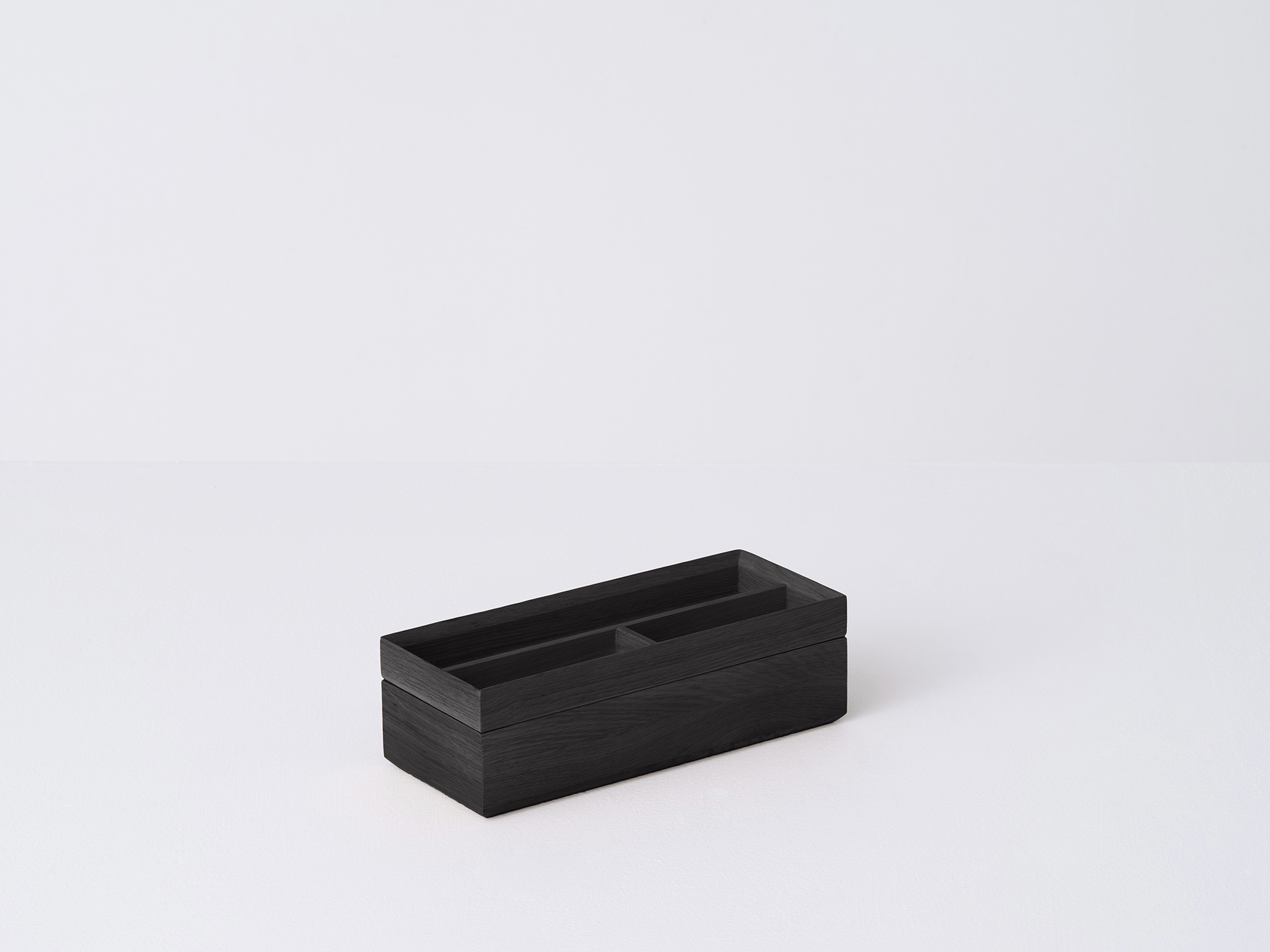 Angled view of the small wooden Draft Pencil Box in black oak