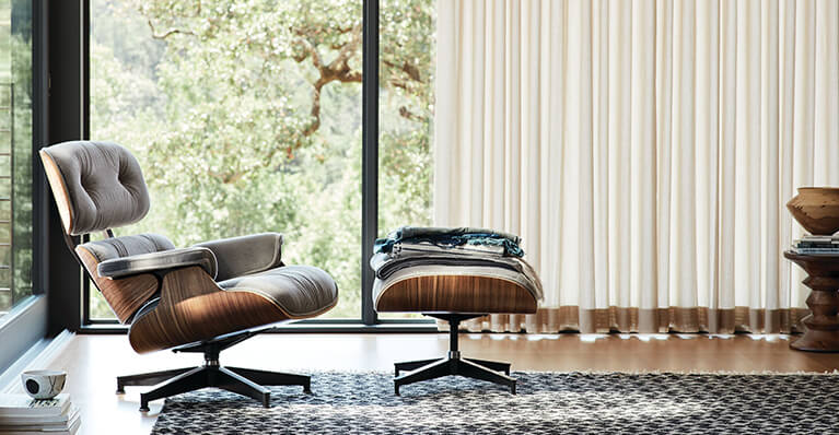 Eames iconic lounge chair and ottoman is display in a living room. Link to Herman Miller Category