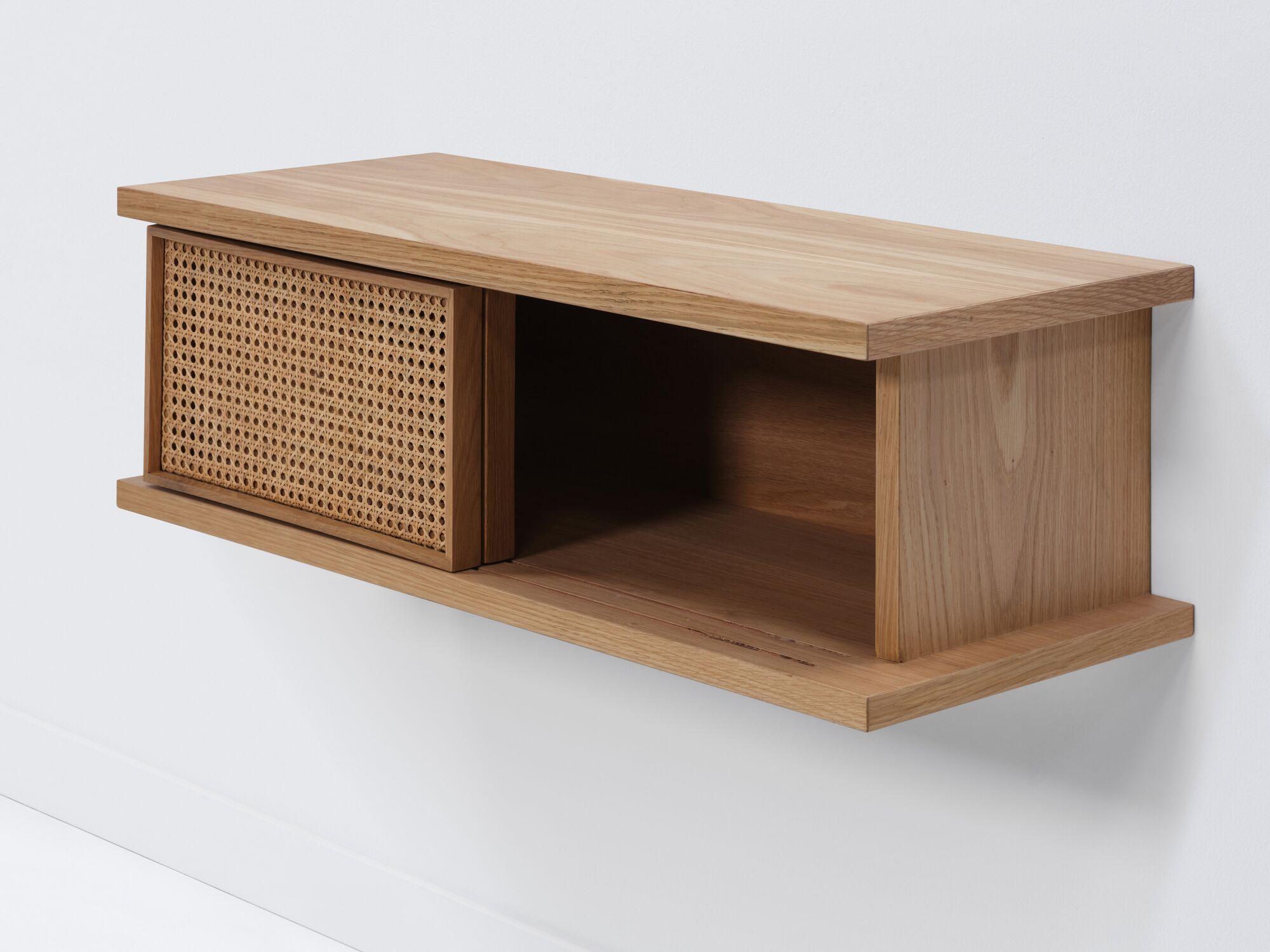 Short oak floating shelf with natural cane doors open detail view