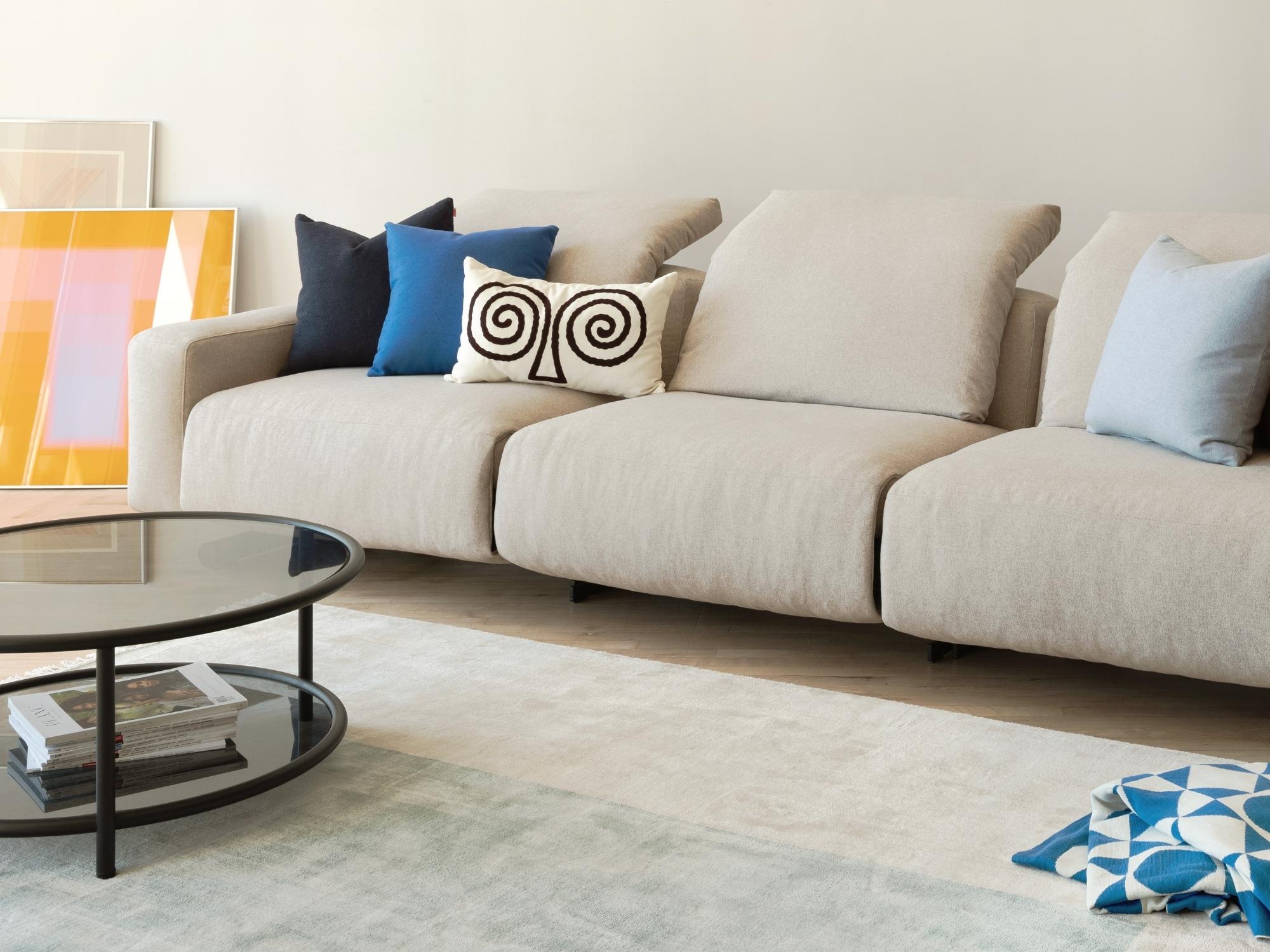Cream and black pattern accent pillow on beige reclining sofa
