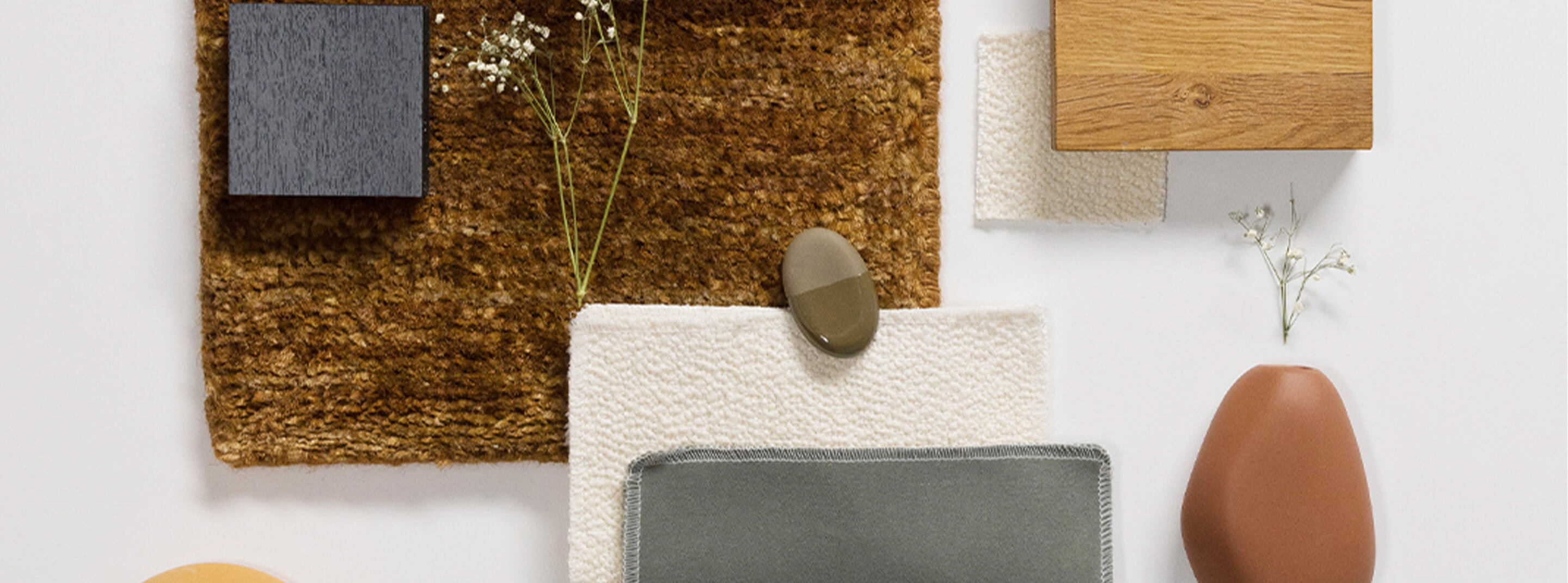 Assortment of small product samples sit on white desk. Link to design services page