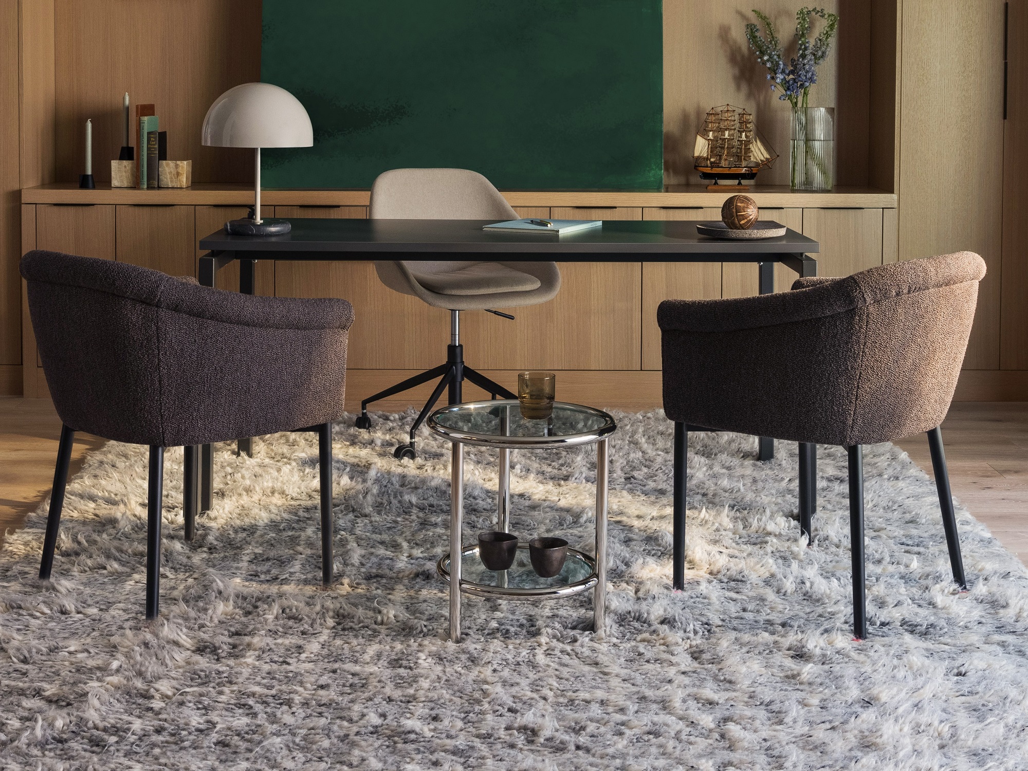 Stainless steel end table between two upholstered chairs in front of a desk