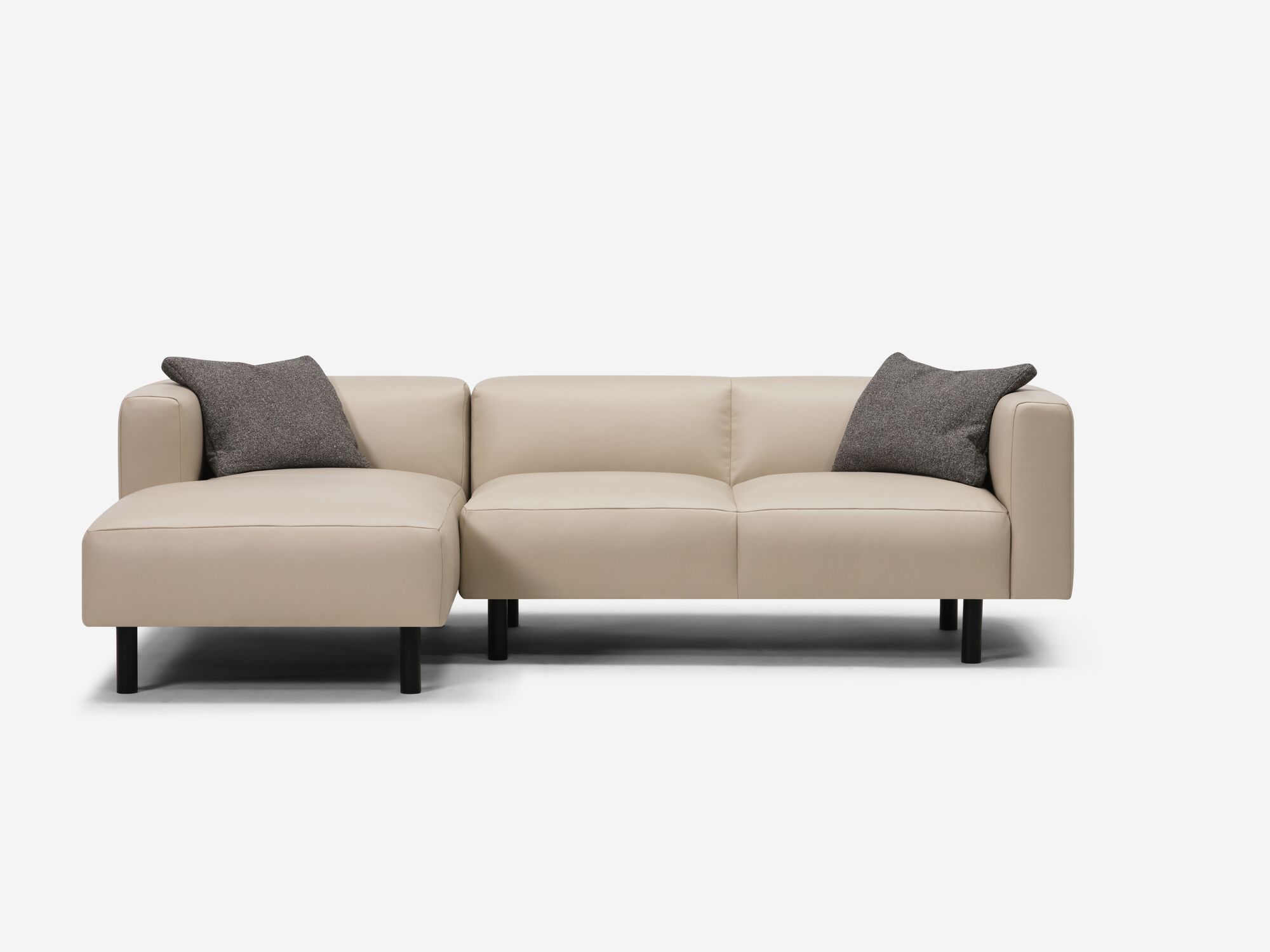 Front view of dark grey toss pillow on beige leather sectional