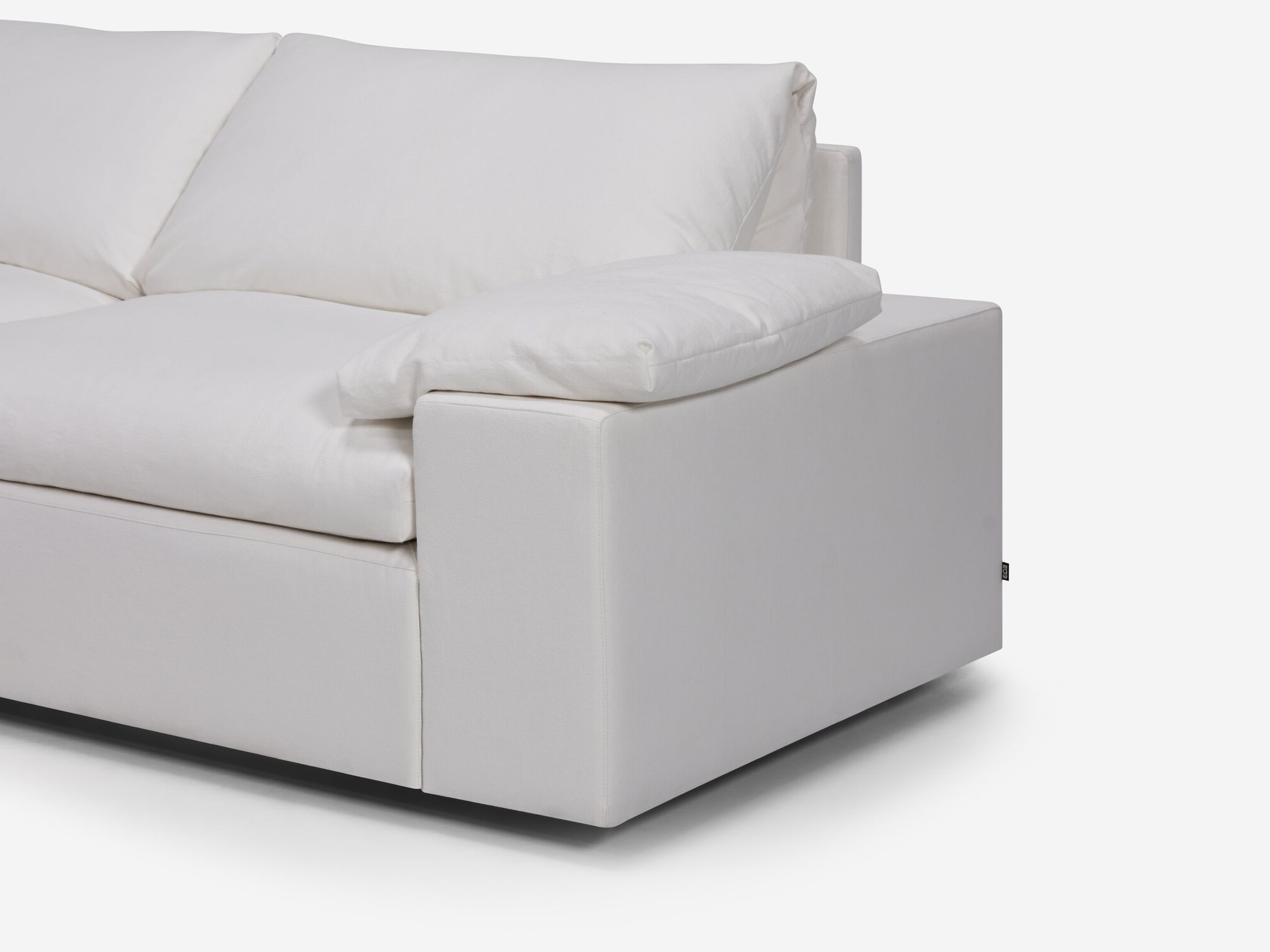 White sectional sofa with left hand chaise, pillow and wide arms seat detail view