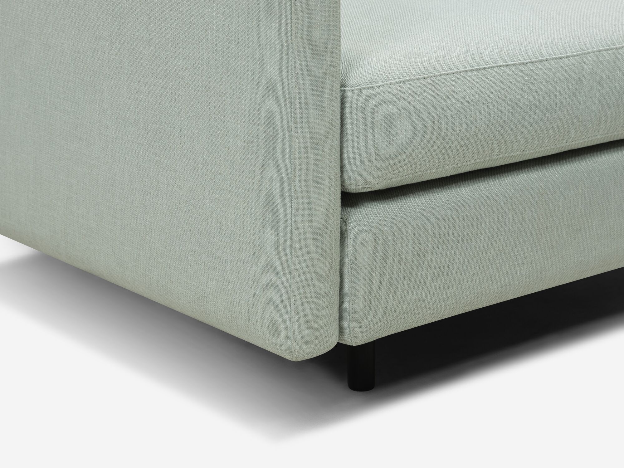 Wide teal armchair leg detail view