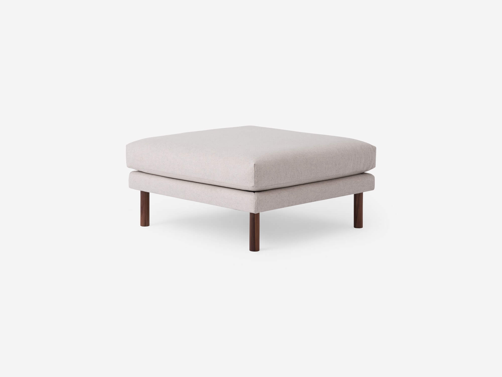 Angled view of the Replay modern ottoman in beige fabric