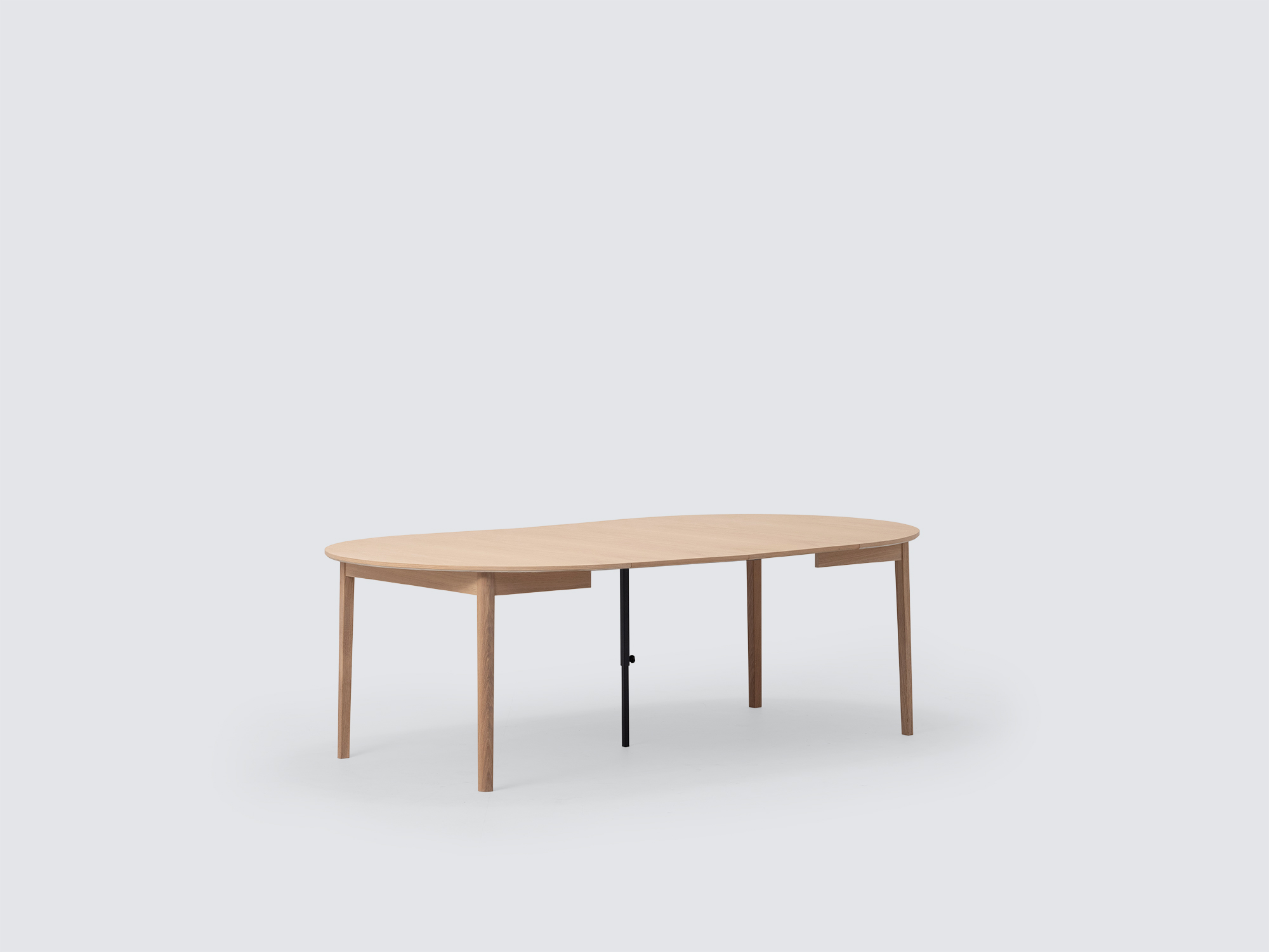 Angled view of the small expanded Ease Expandable Dining Table in oak