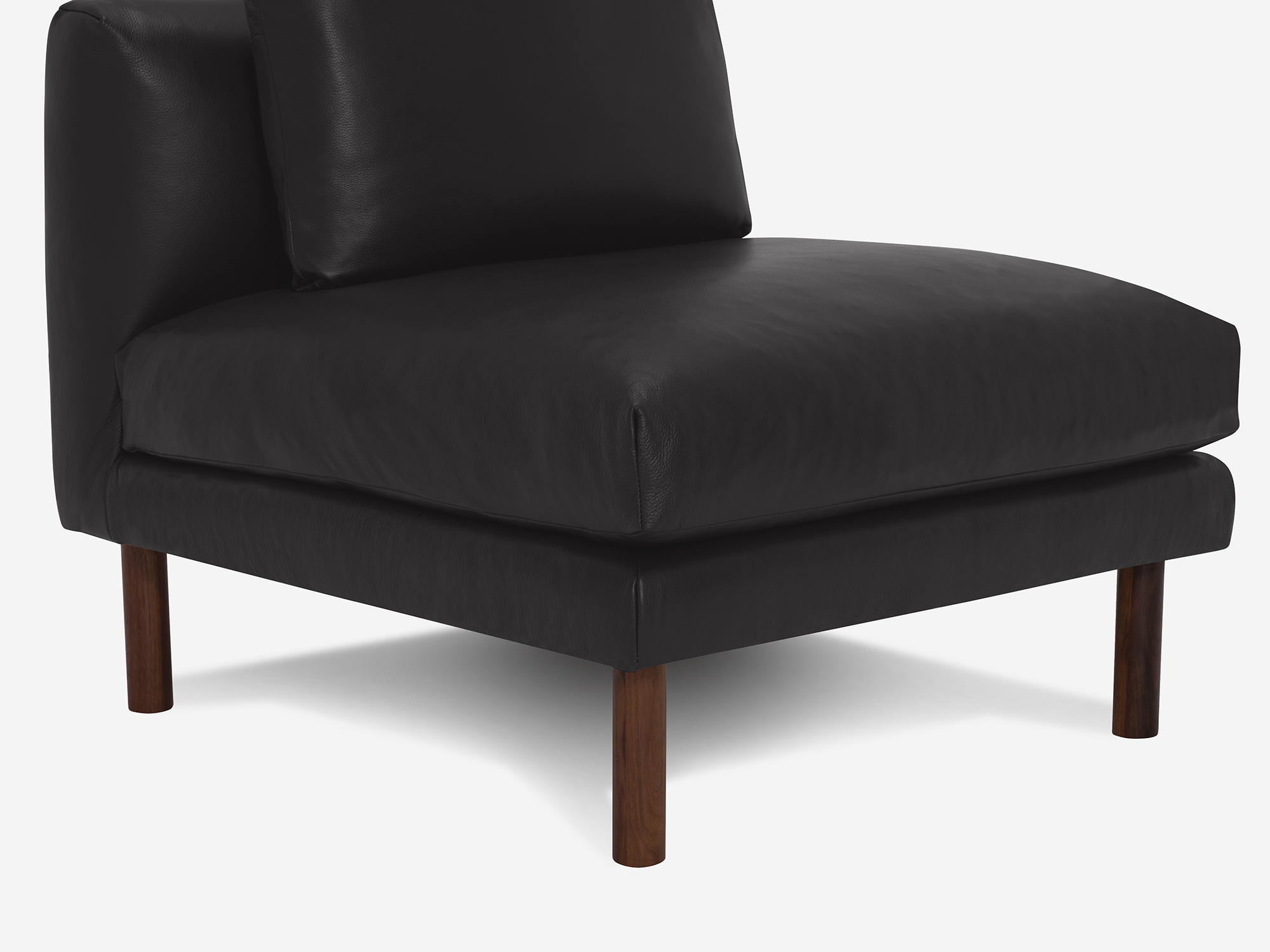 Detail view of black leather armless chair with cushion