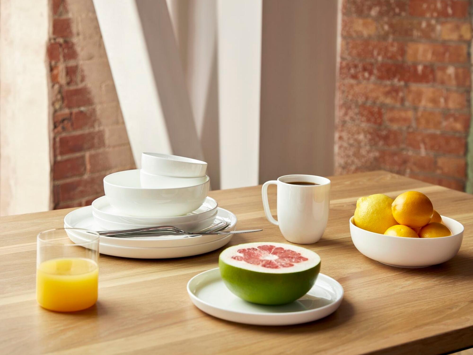 White bowls stacked with different sized bowls beside coffee table