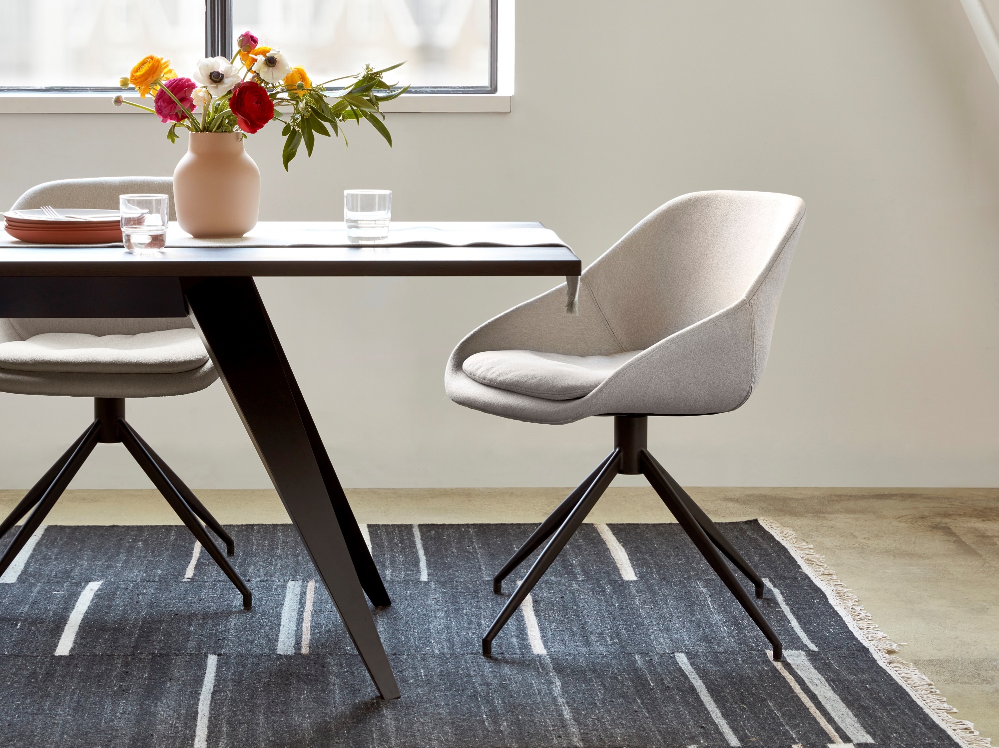 Beige upholstered dining chair at black modern dining room table