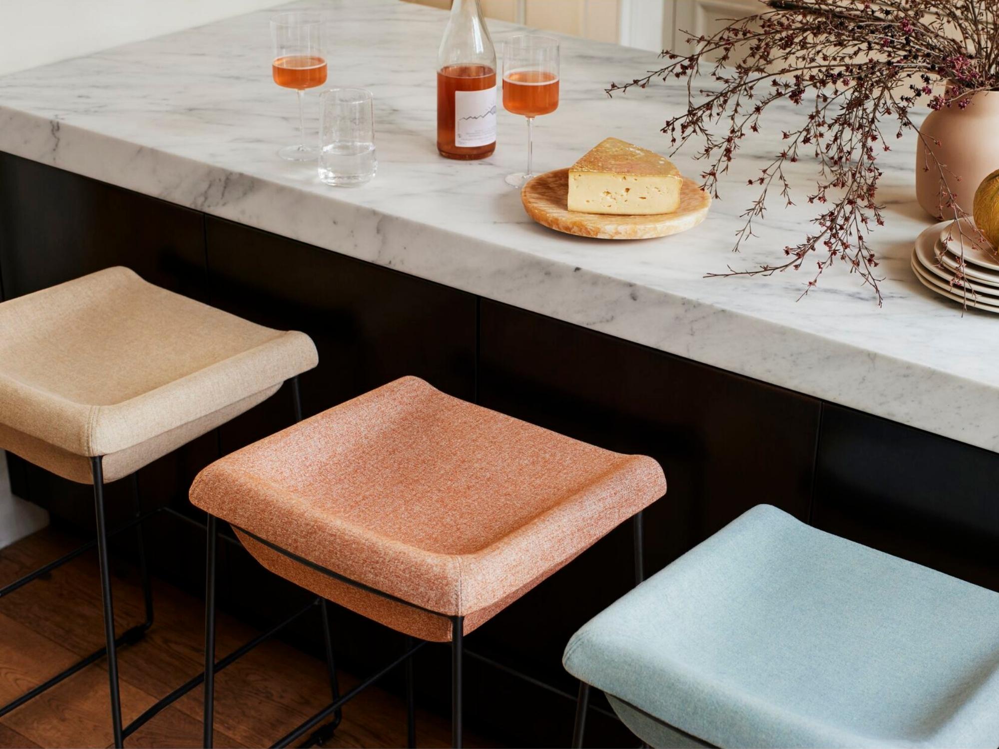 Pastel coloured upholstered counter height stool at colorful kitchen island