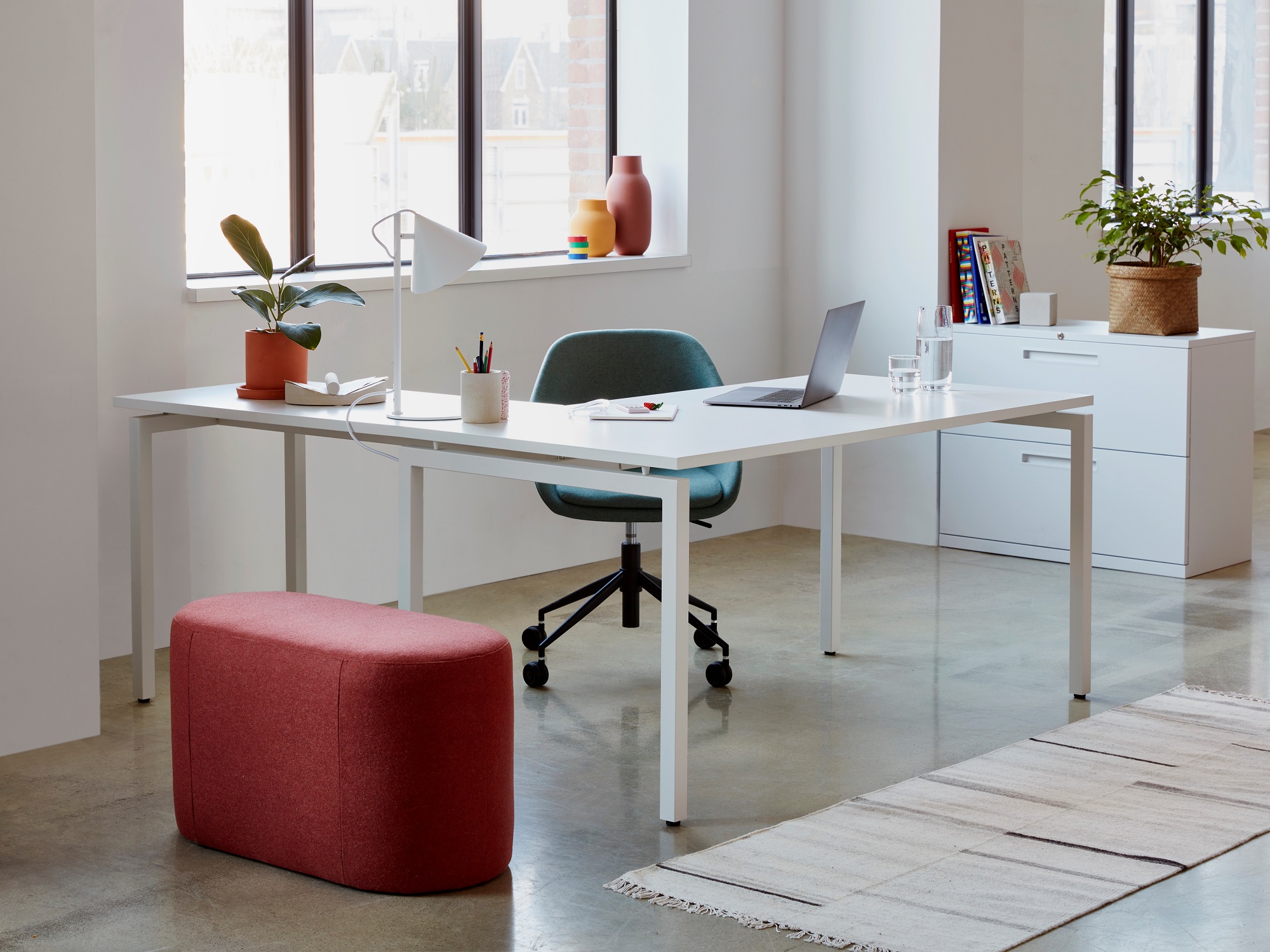 White home office with white desk, blue office chair, and white filing cabinet