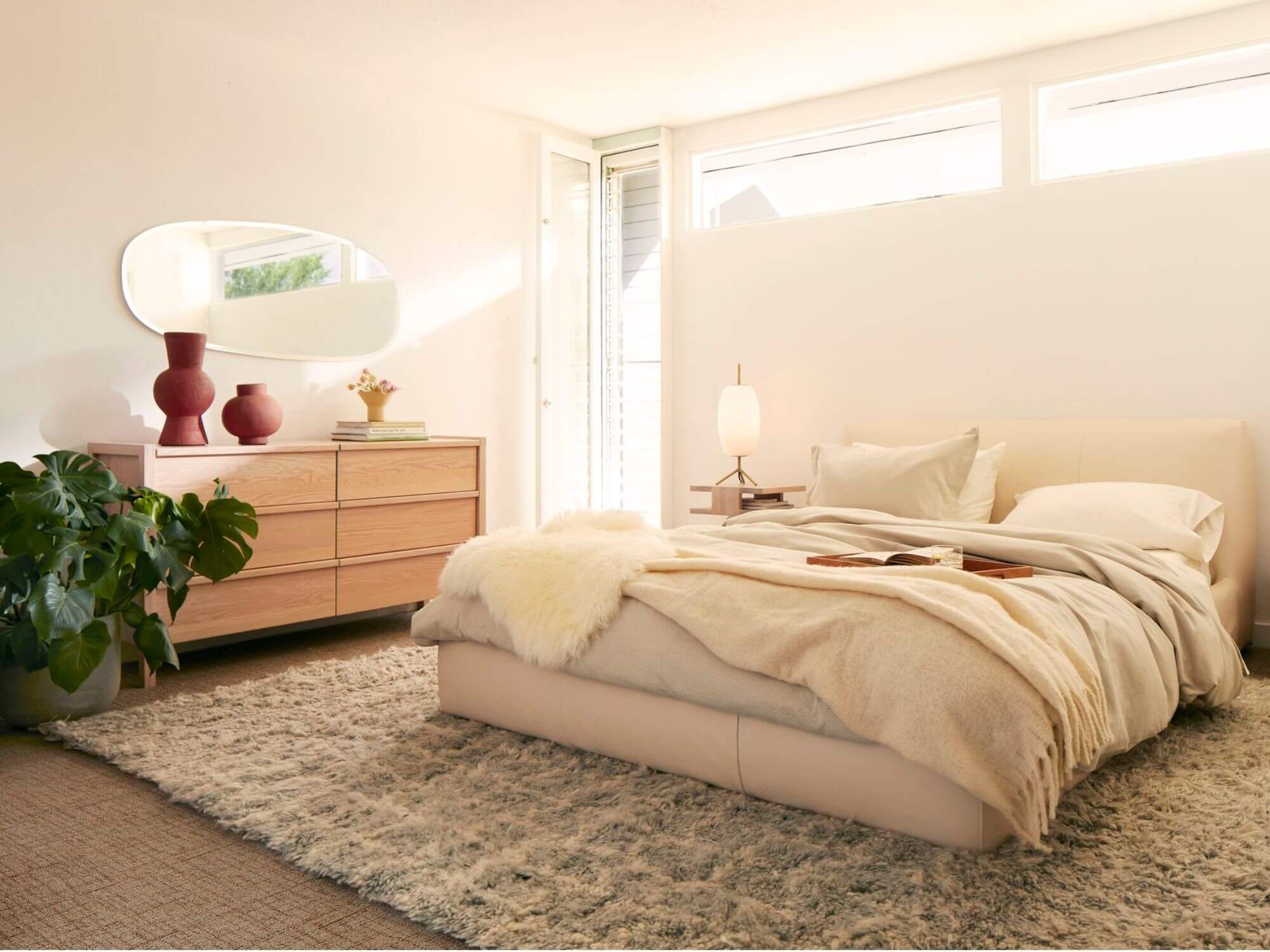 White and brass table lamp on floating nightstand in bedroom