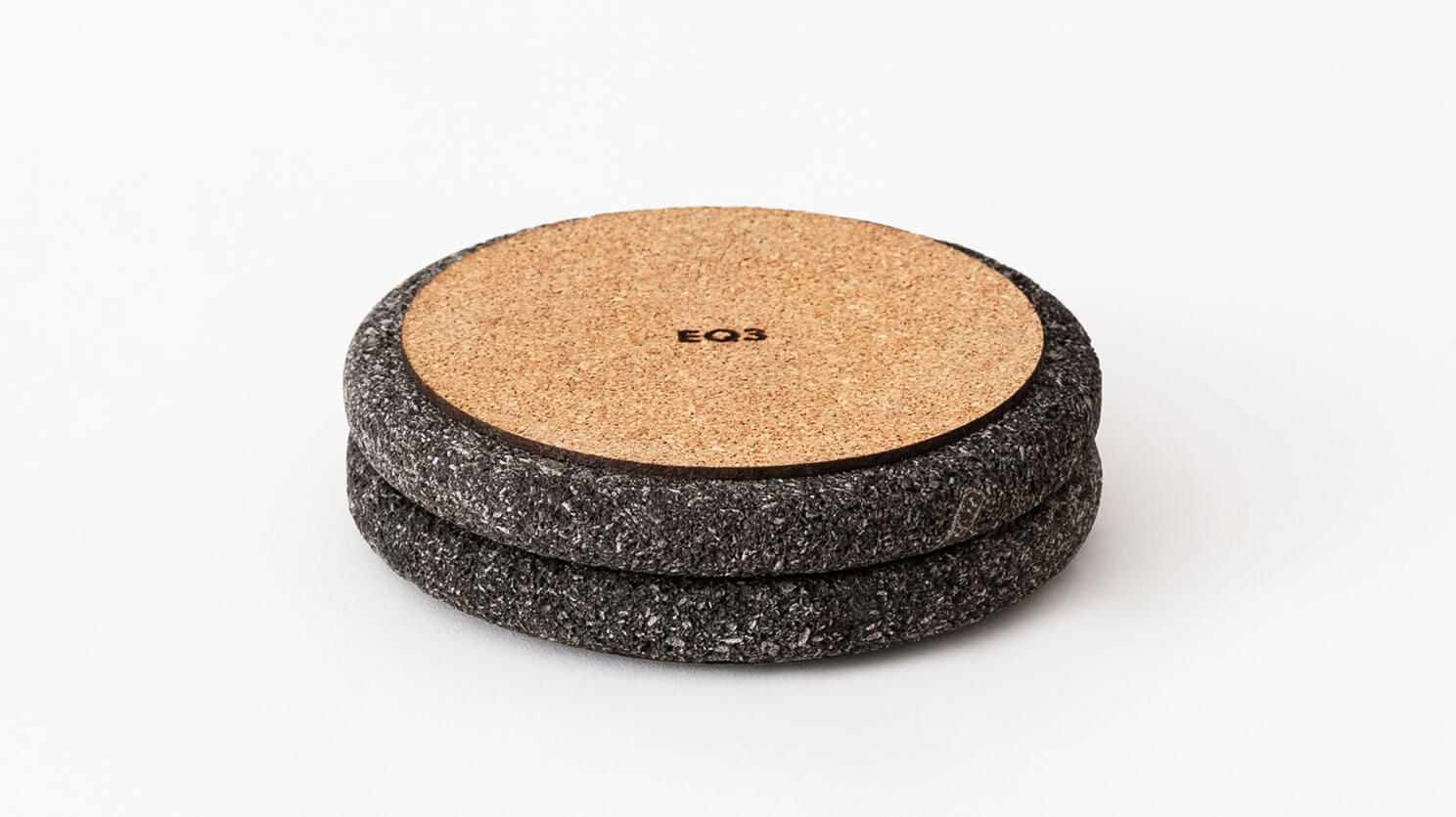 Two coasters in lava stone flipped upside down to reveal cork padding