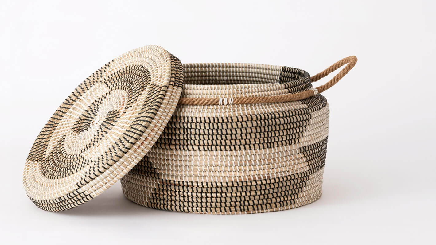 Side view of large woven black and beige basket with lid off