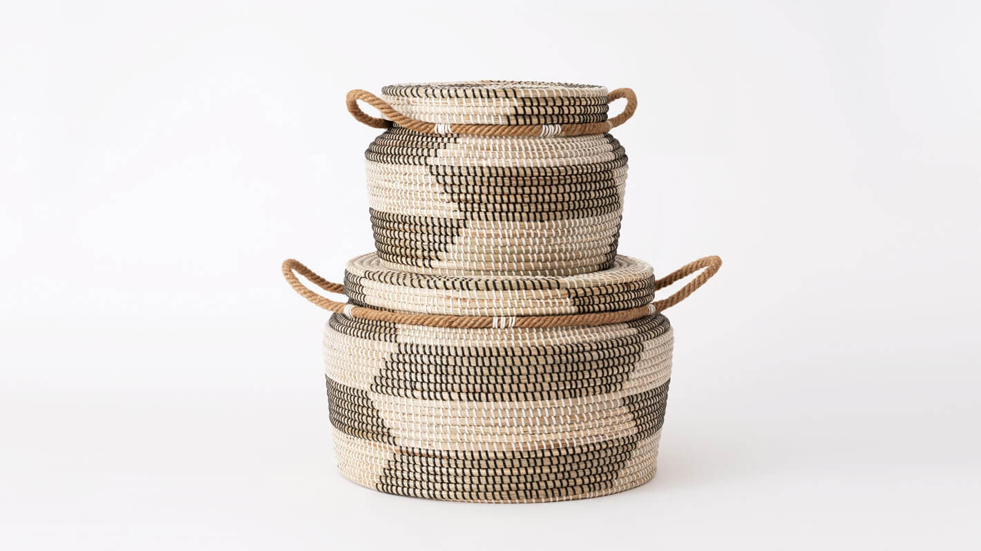 Side view of medium and large woven black and beige basket stacked