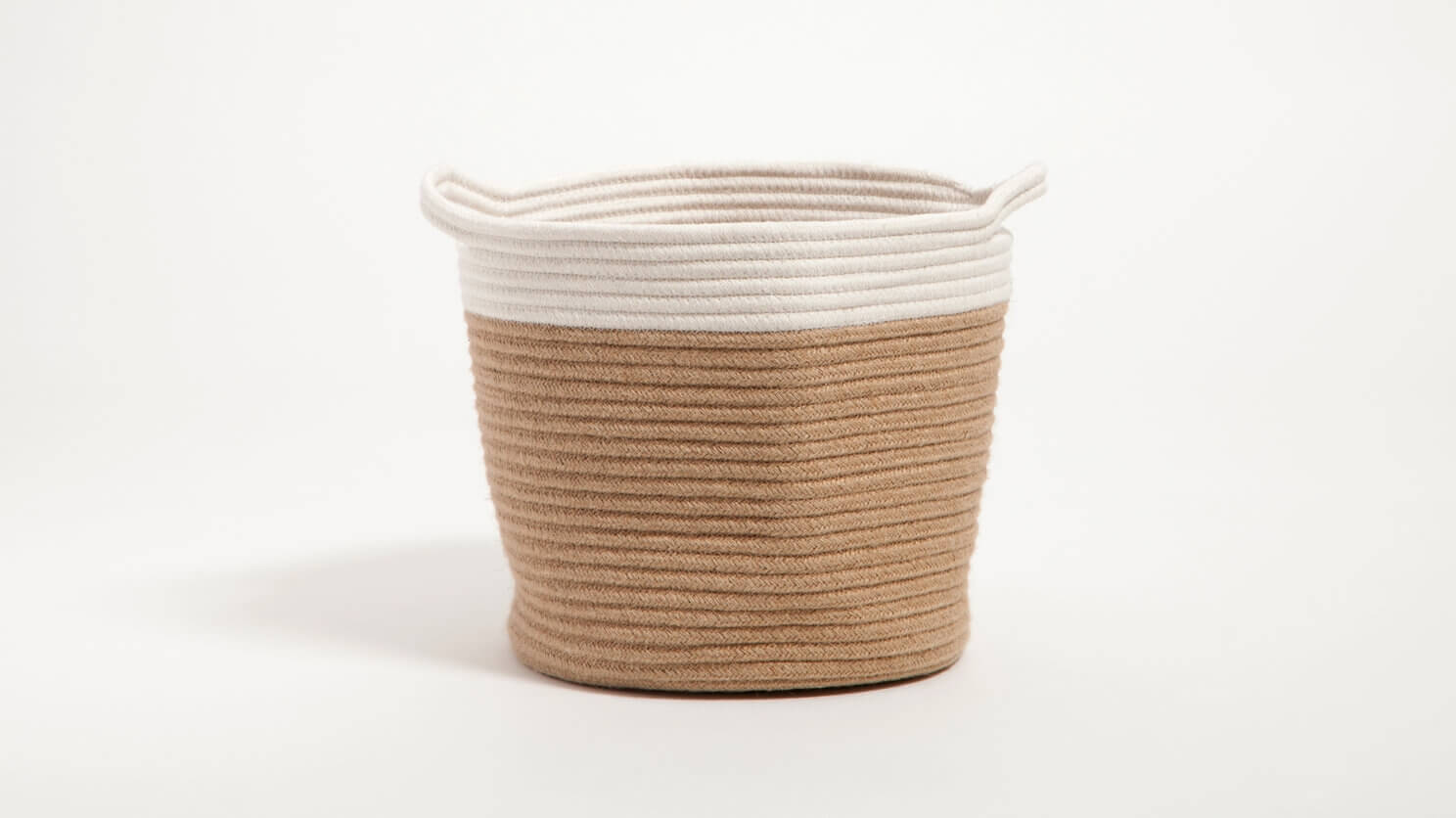 Side view of ivory and cream woven basket with handles