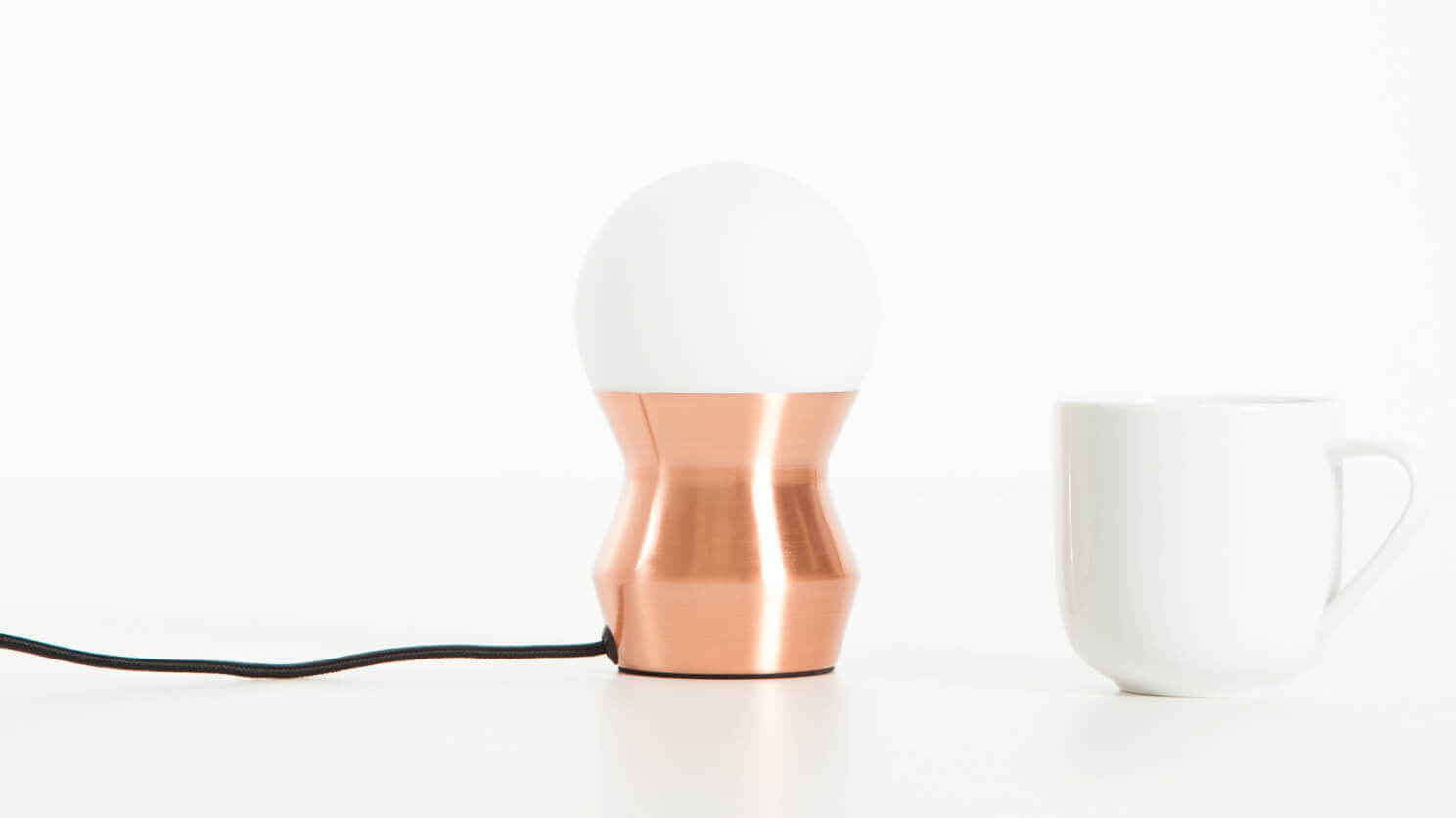 The Token cute table lamp in copper with a coffee cup