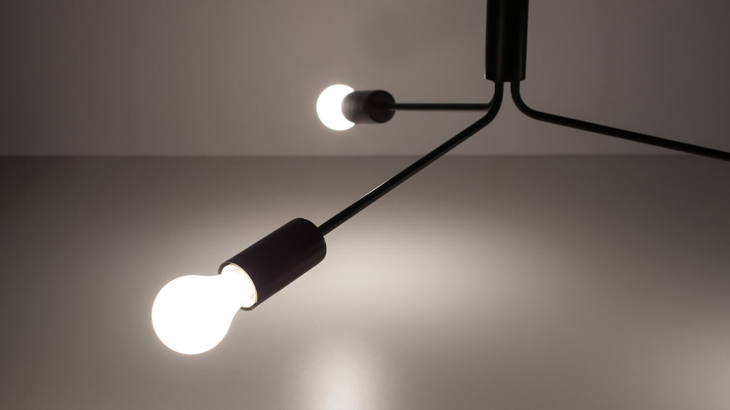 Detail view of the Grand Metro modern pendant lamp in black with light on