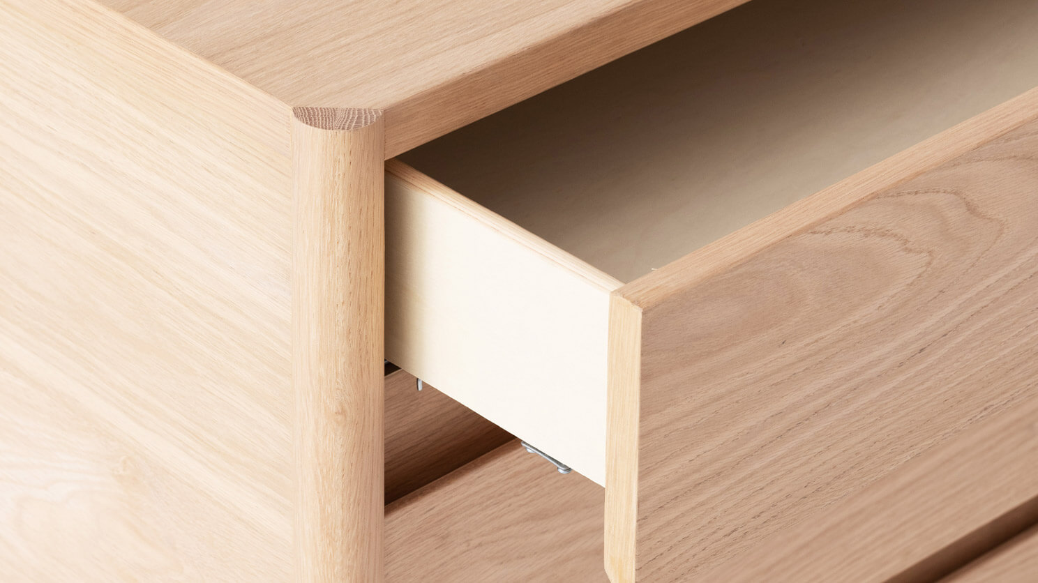 Detail view of the Monarch bedroom chest in oak with open drawer