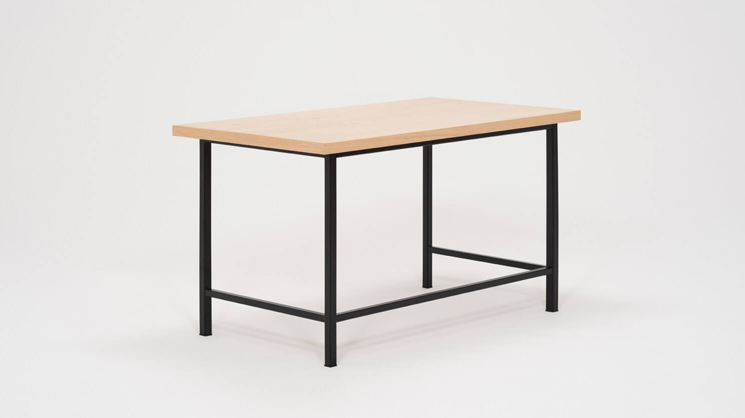 Angled view of the Kendall studio desk with oak veneer top and black base