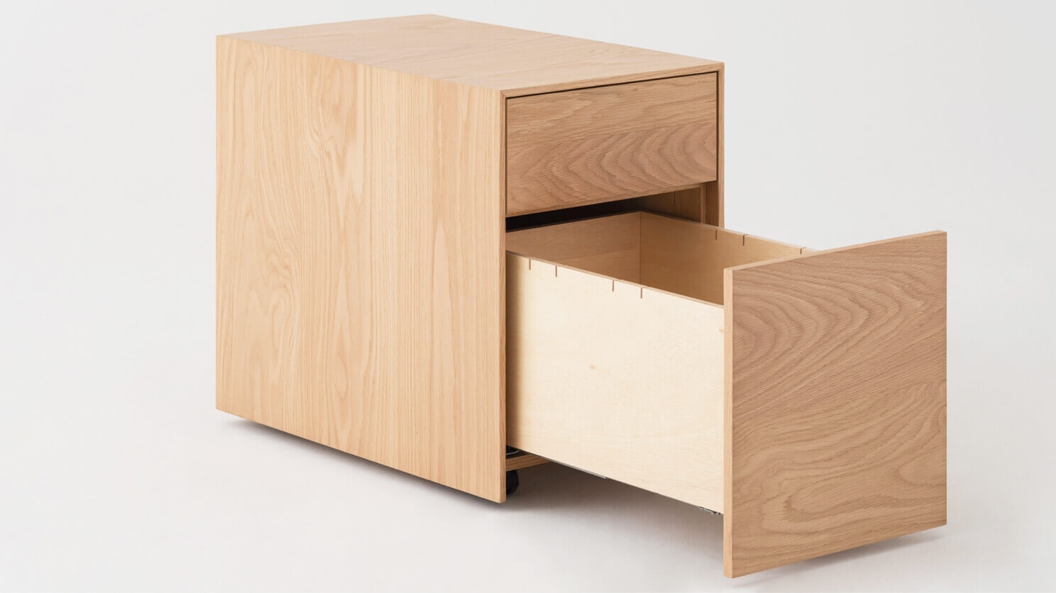 Oak filing cabinet with bottom drawer open front angle view