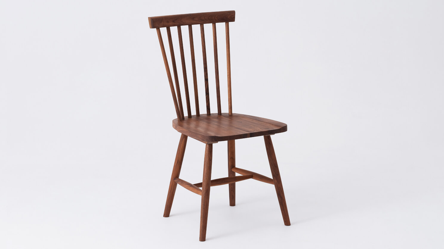 Angled view of the Lyla modern side dining room chair in solid walnut