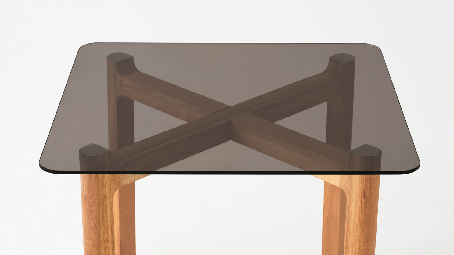 Detail view of the Place square contemporary dinette table with brown glass top and oak legs