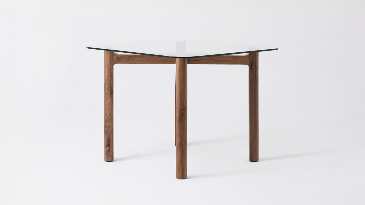 Side view of the Place square contemporary dinette table with clear glass top and walnut legs