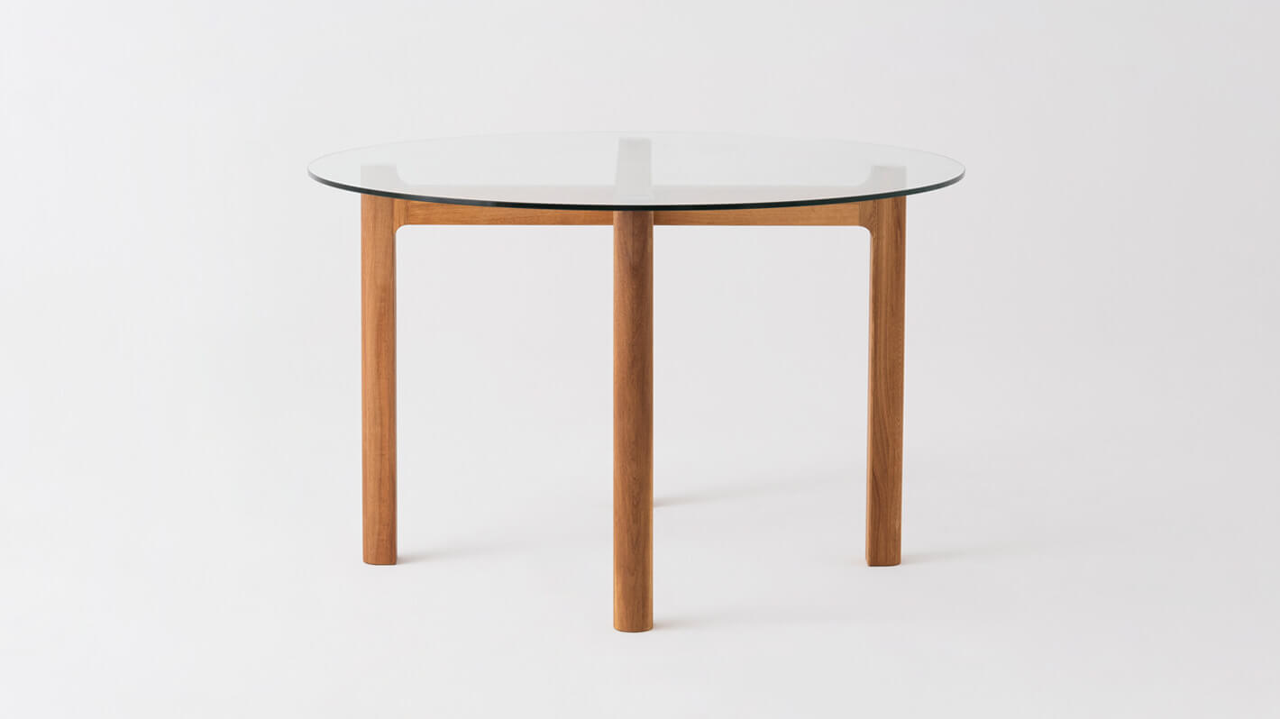 Side view of the Place round contemporary dinette table with clear glass top and oak legs