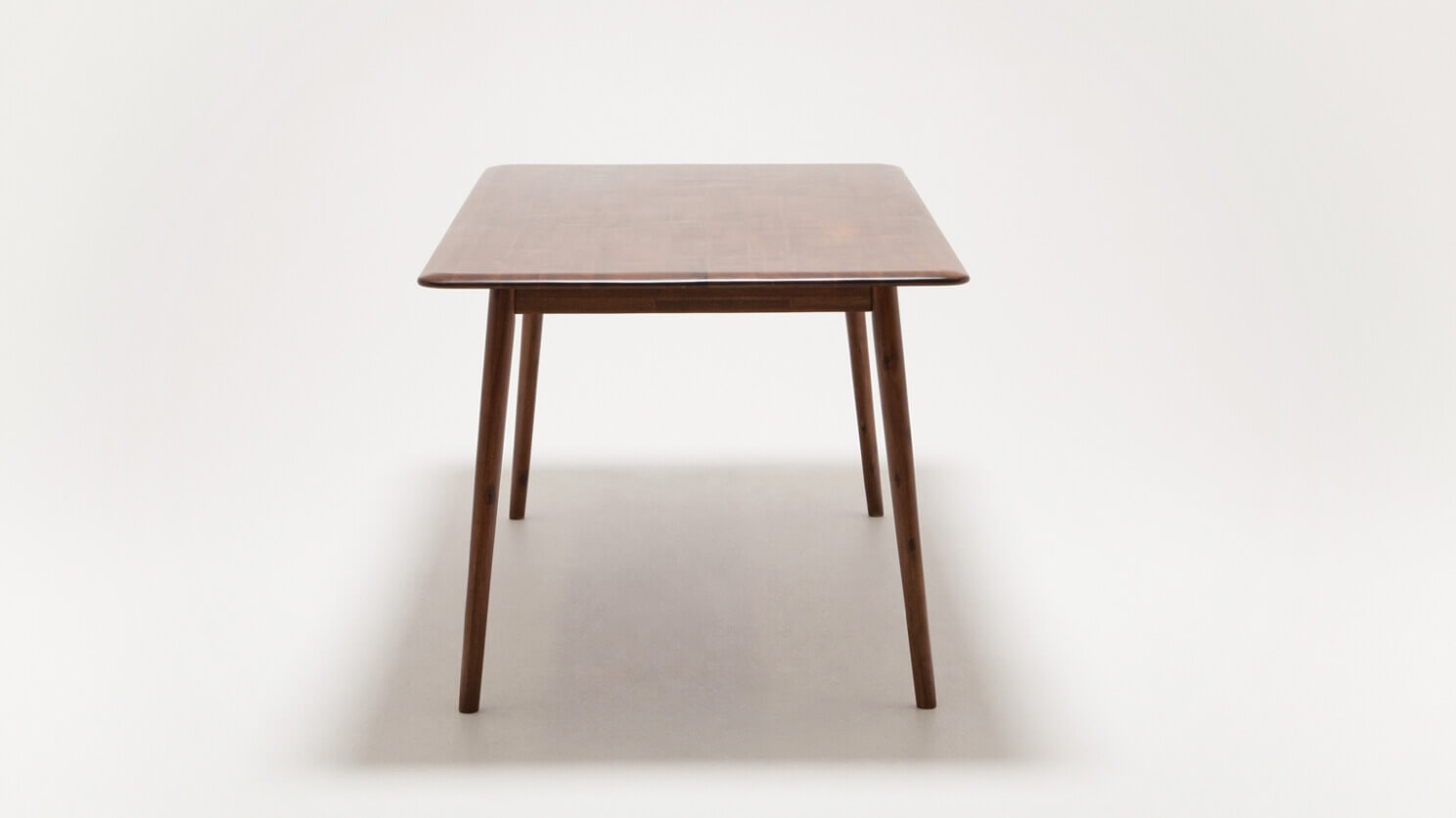 Side view of the small Kacia solid wood dining table in java