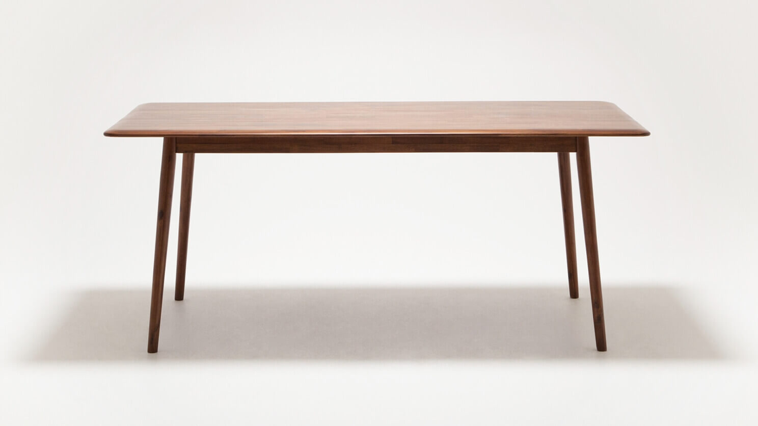 Front view of the medium sized Kacia solid wood dining table in java