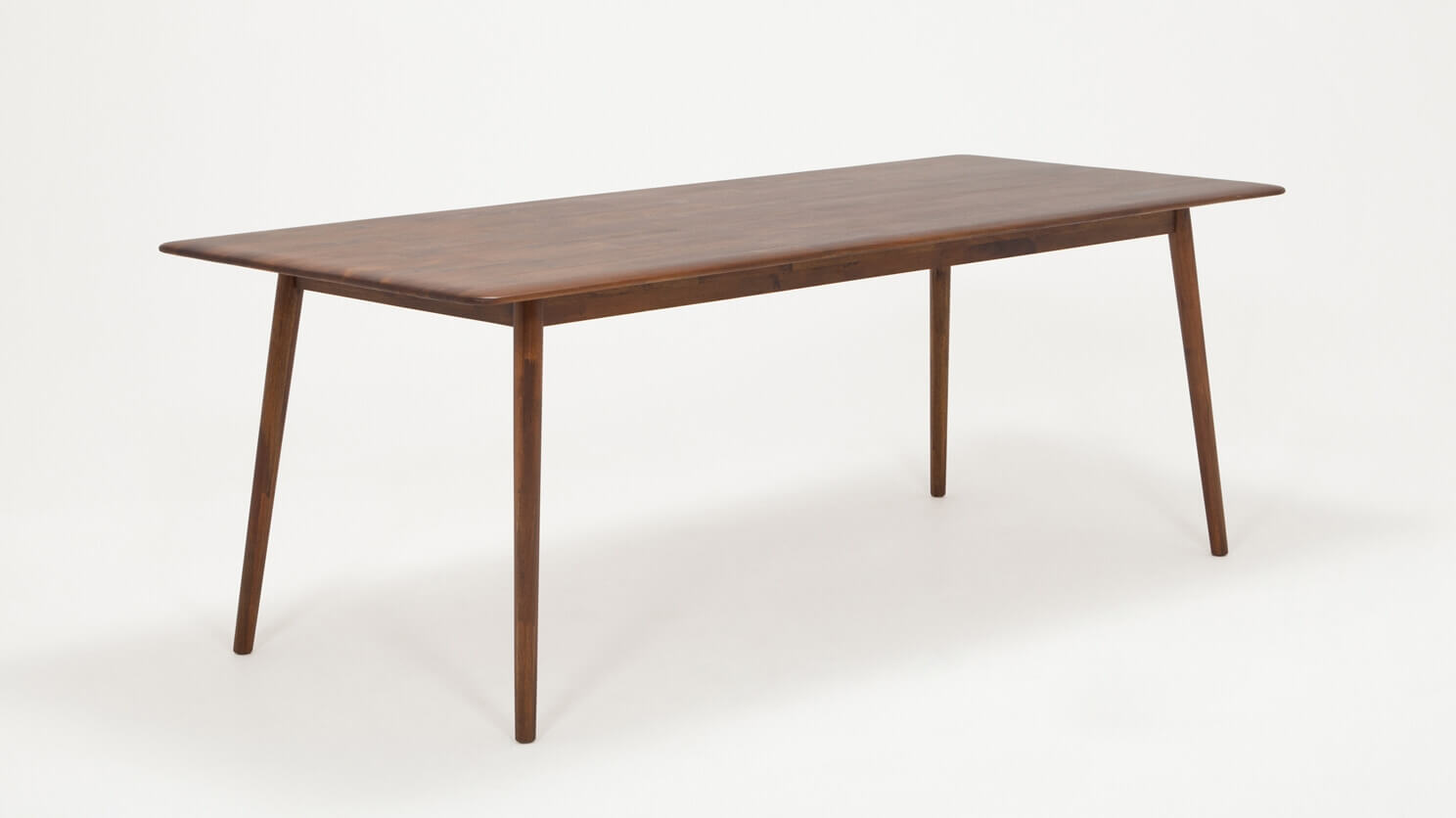 Angled view of the large Kacia solid wood dining table in java