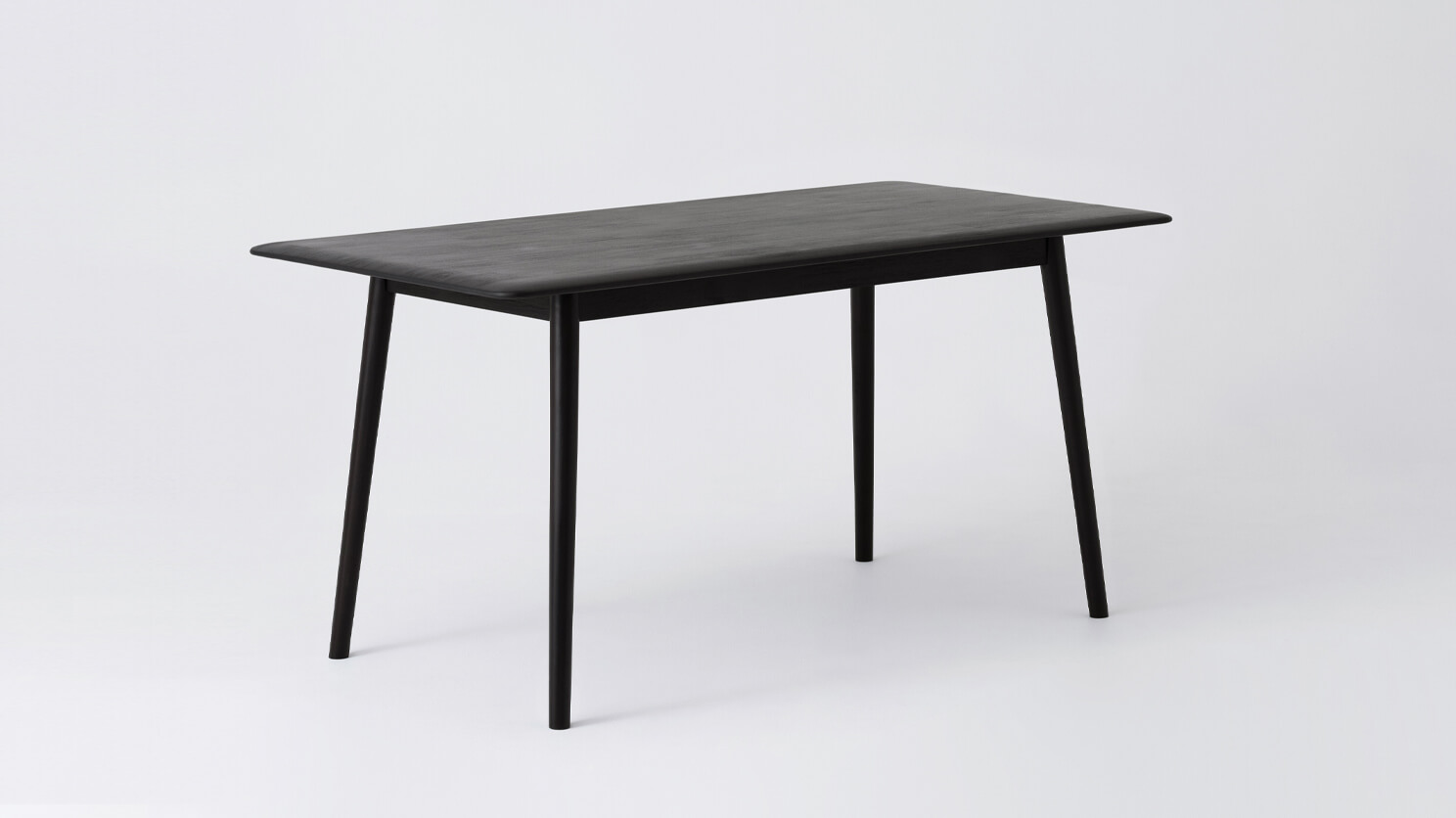 Angled view of the small Kacia solid wood dining table in black