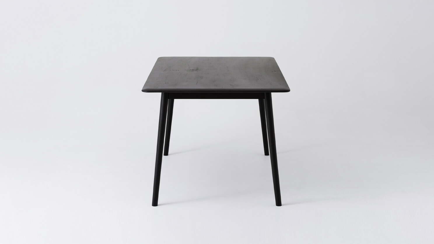 Side view of the medium sized Kacia solid wood dining table in black