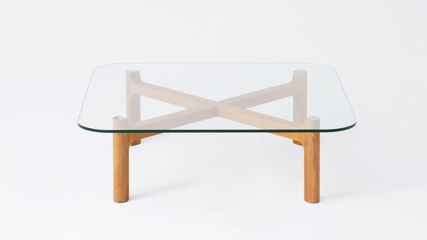 Side view of the Place large square coffee table with clear glass top and oak legs