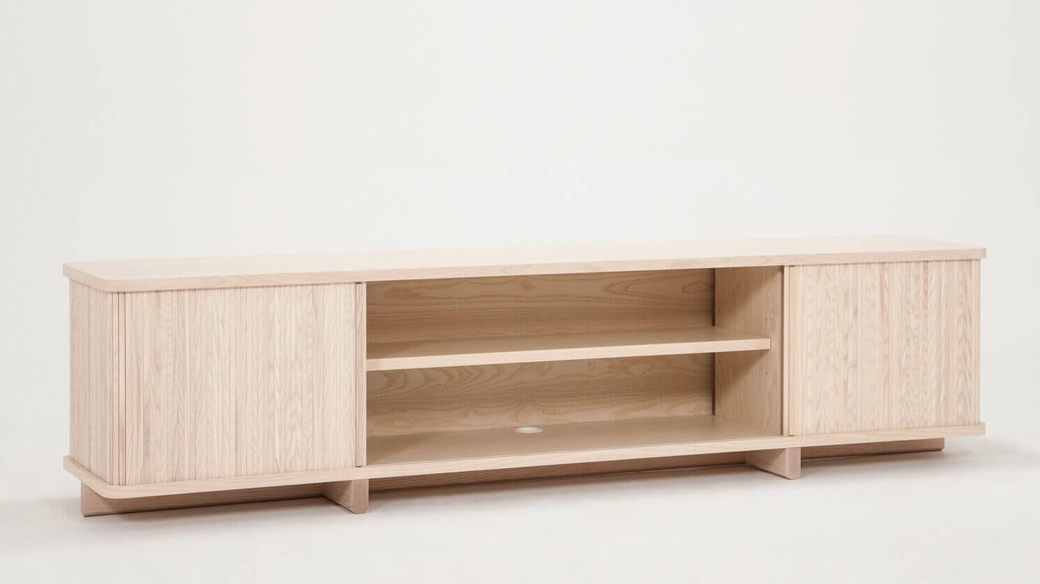 Angled view of the Tambour mid century media console in ash with open drawers