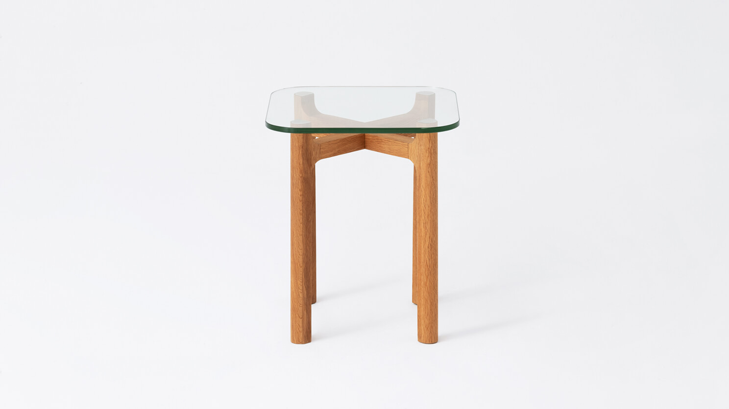 Front view of the Place square accent table with clear glass top and oak legs